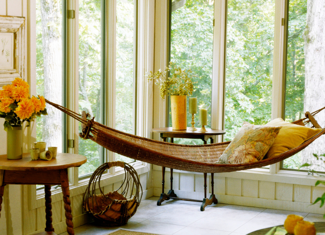 Sun room with hammock and view of nature.