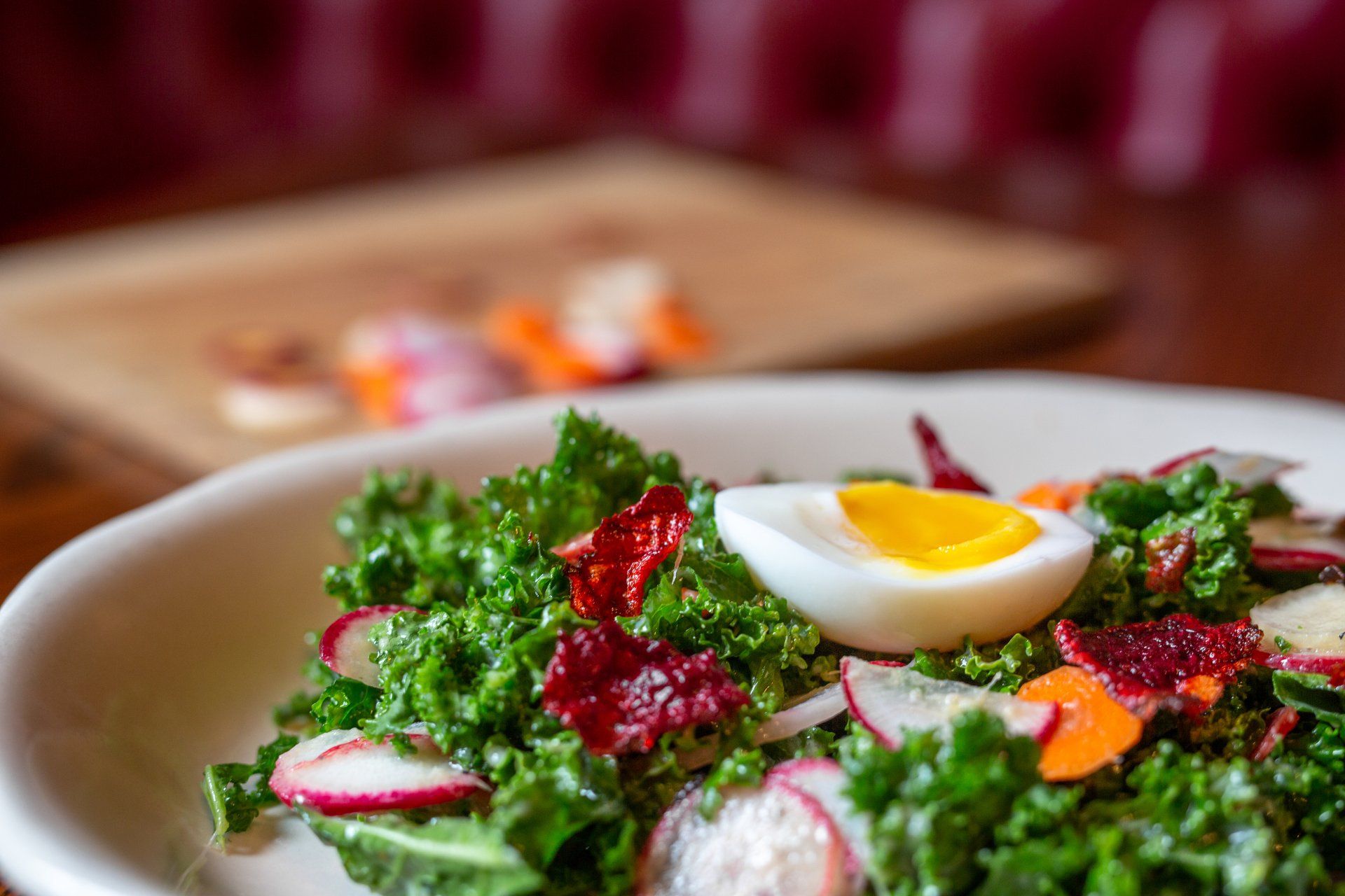 kale salad topped with radish and egg