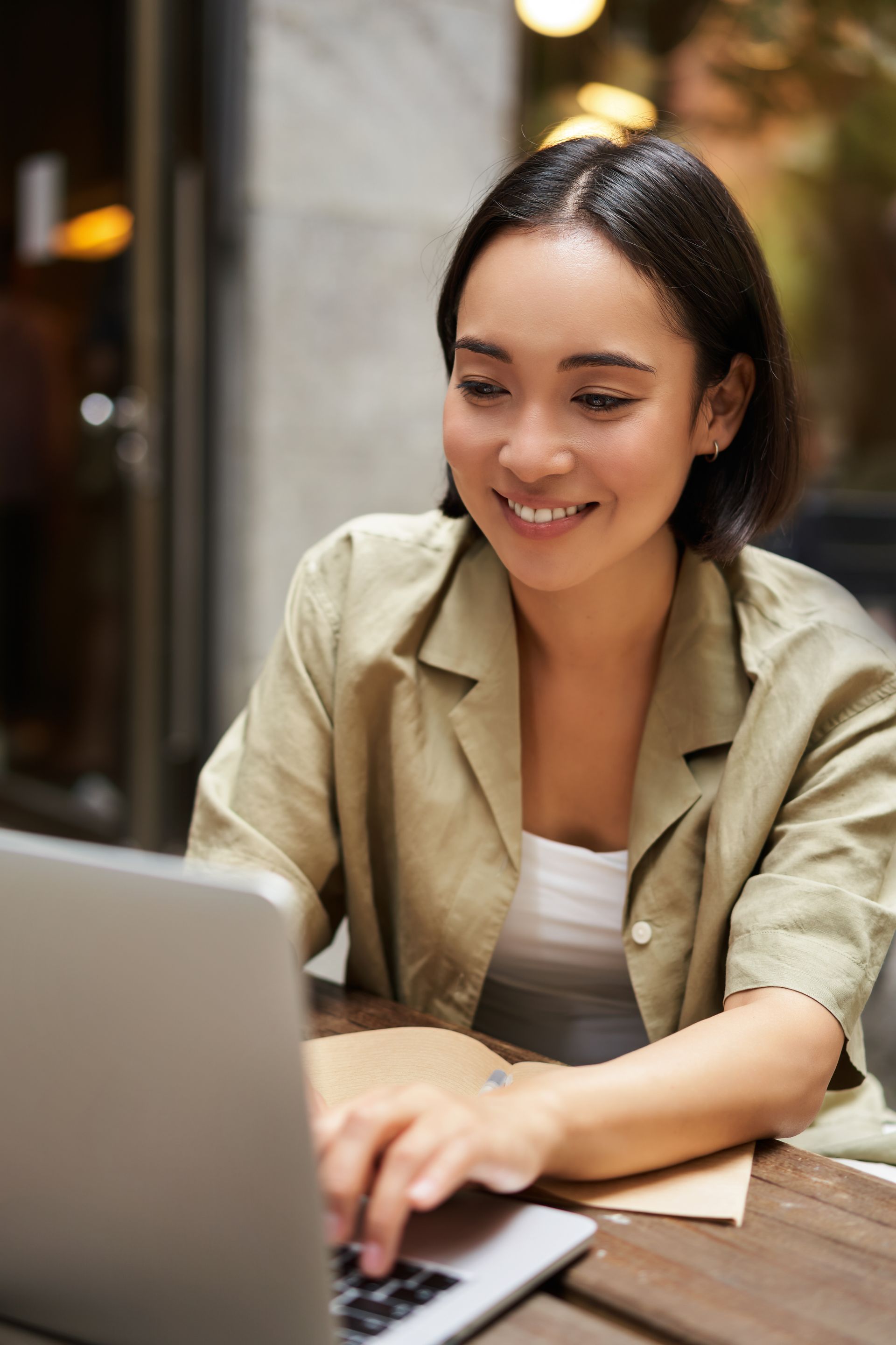 A woman is sitting at a table using a laptop computer.