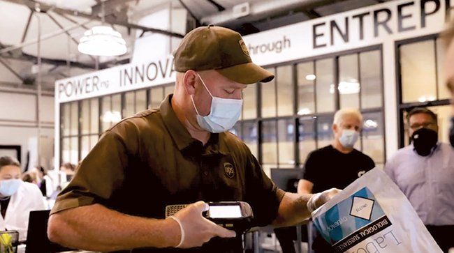 A UPS driver scans a COVID test kit for shipment. (UPS Healthcare)