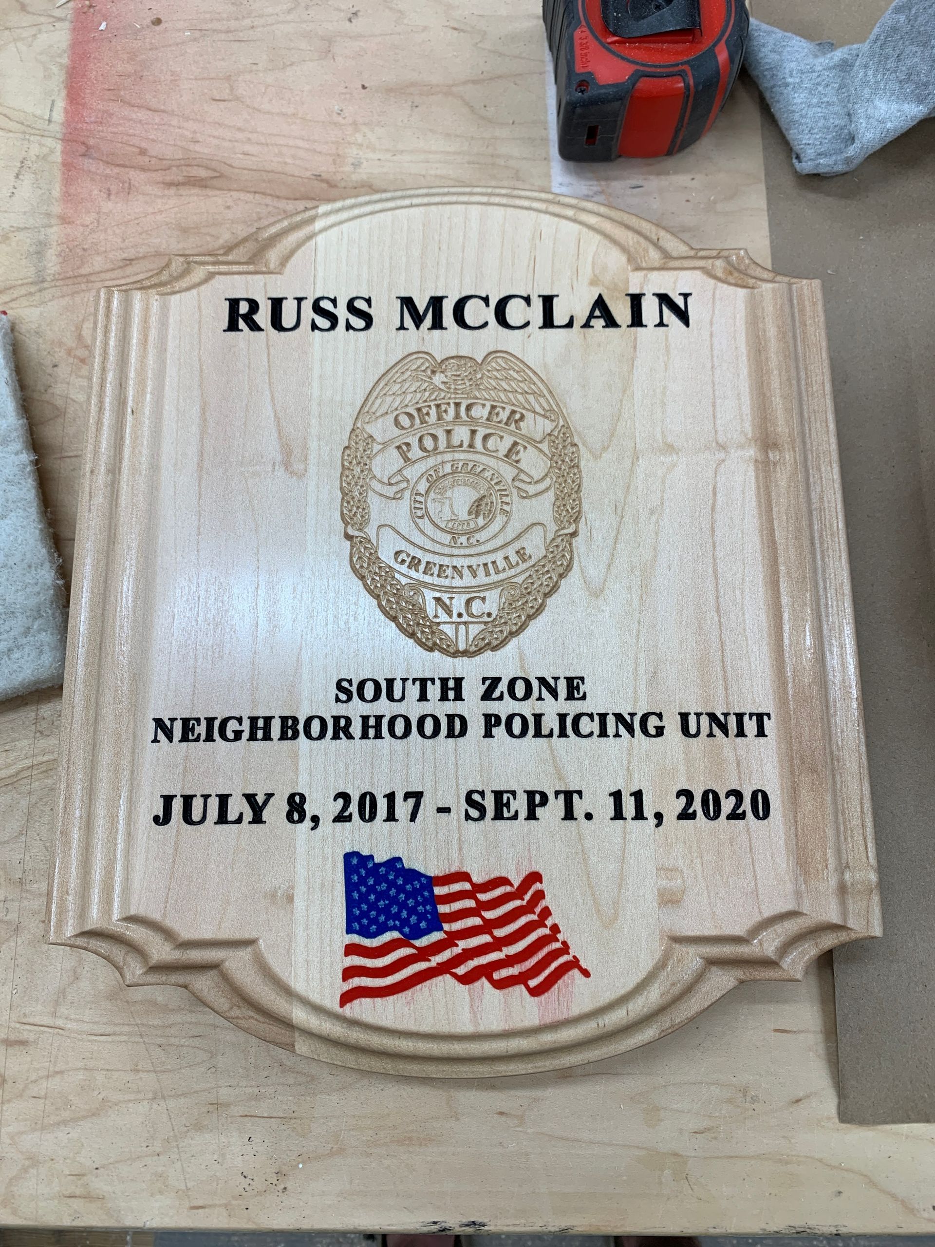 A wooden plaque for russ mcclain from the south zone neighborhood policing unit