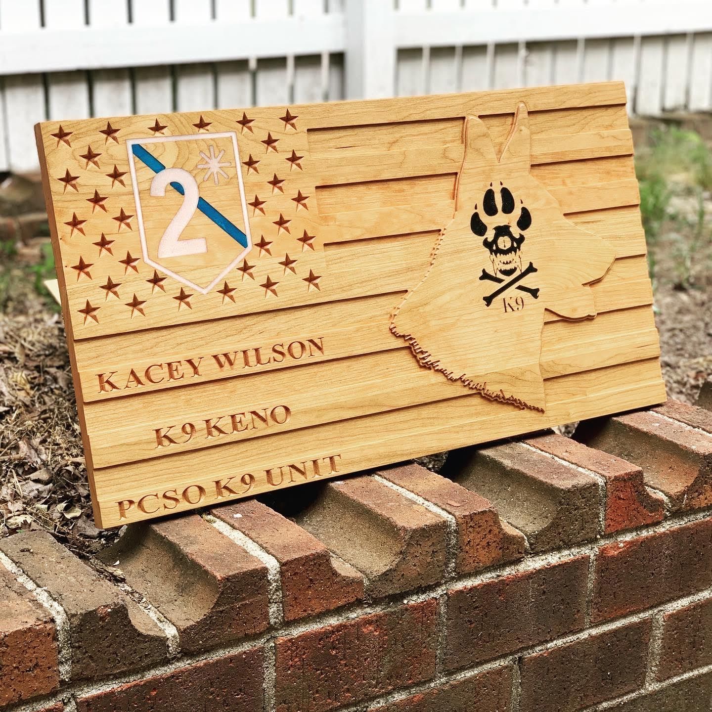 A wooden american flag is sitting on top of a brick wall.