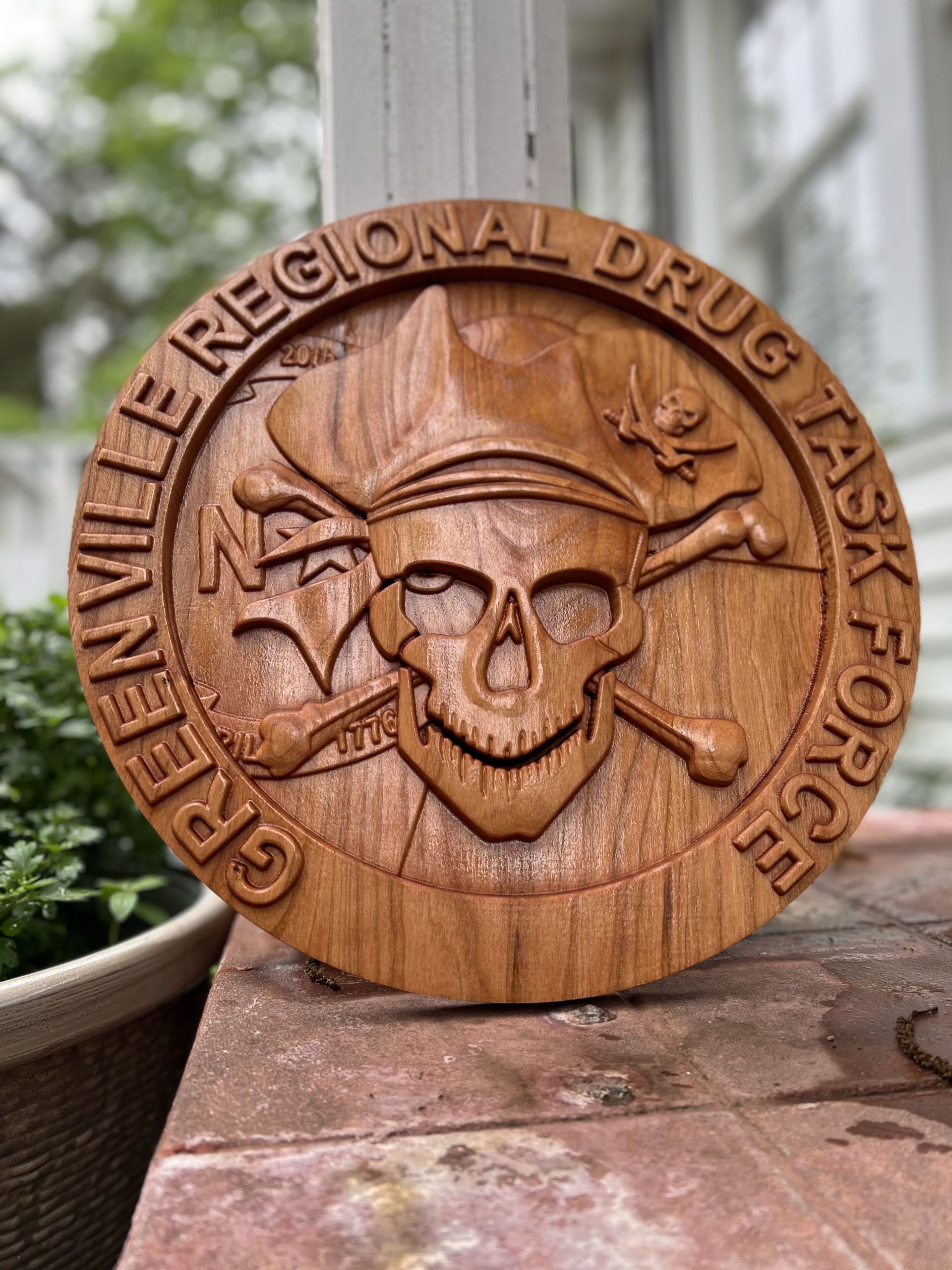 A wooden coin with a skull and crossbones says greenville regional drug task force