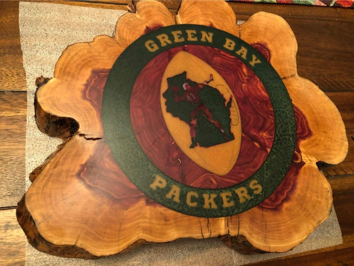 A green bay packers logo on a piece of wood