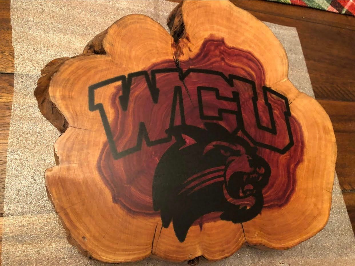 A piece of wood with the wcu logo on it