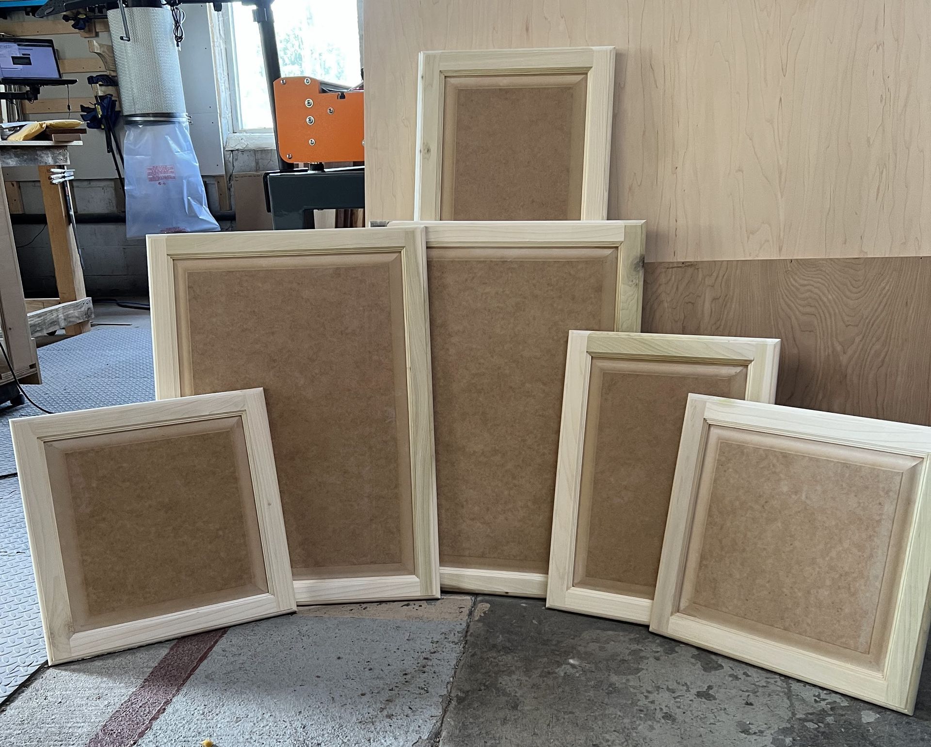 A bunch of picture frames are sitting on the floor