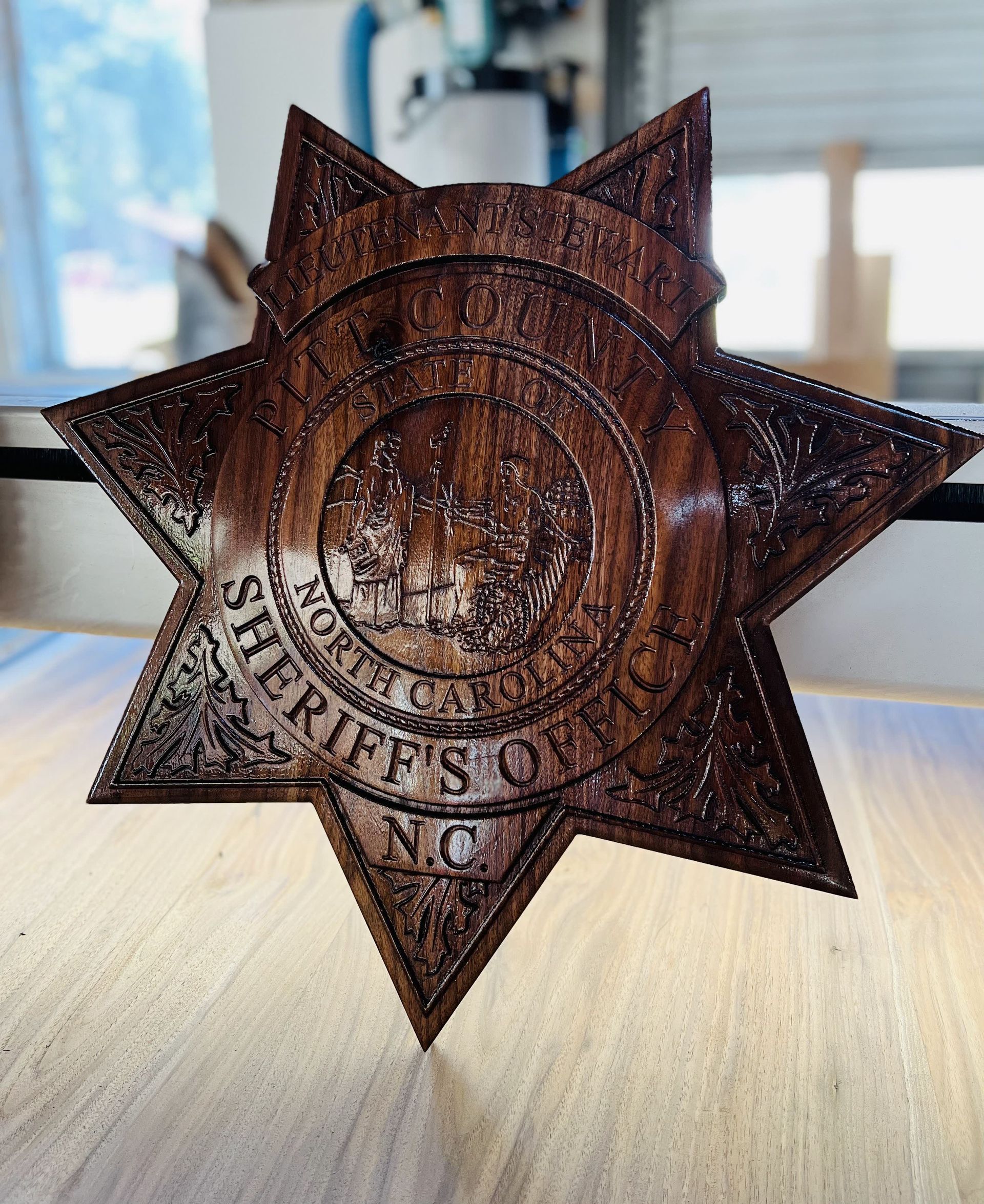 A wooden sheriff 's badge is sitting on a wooden table