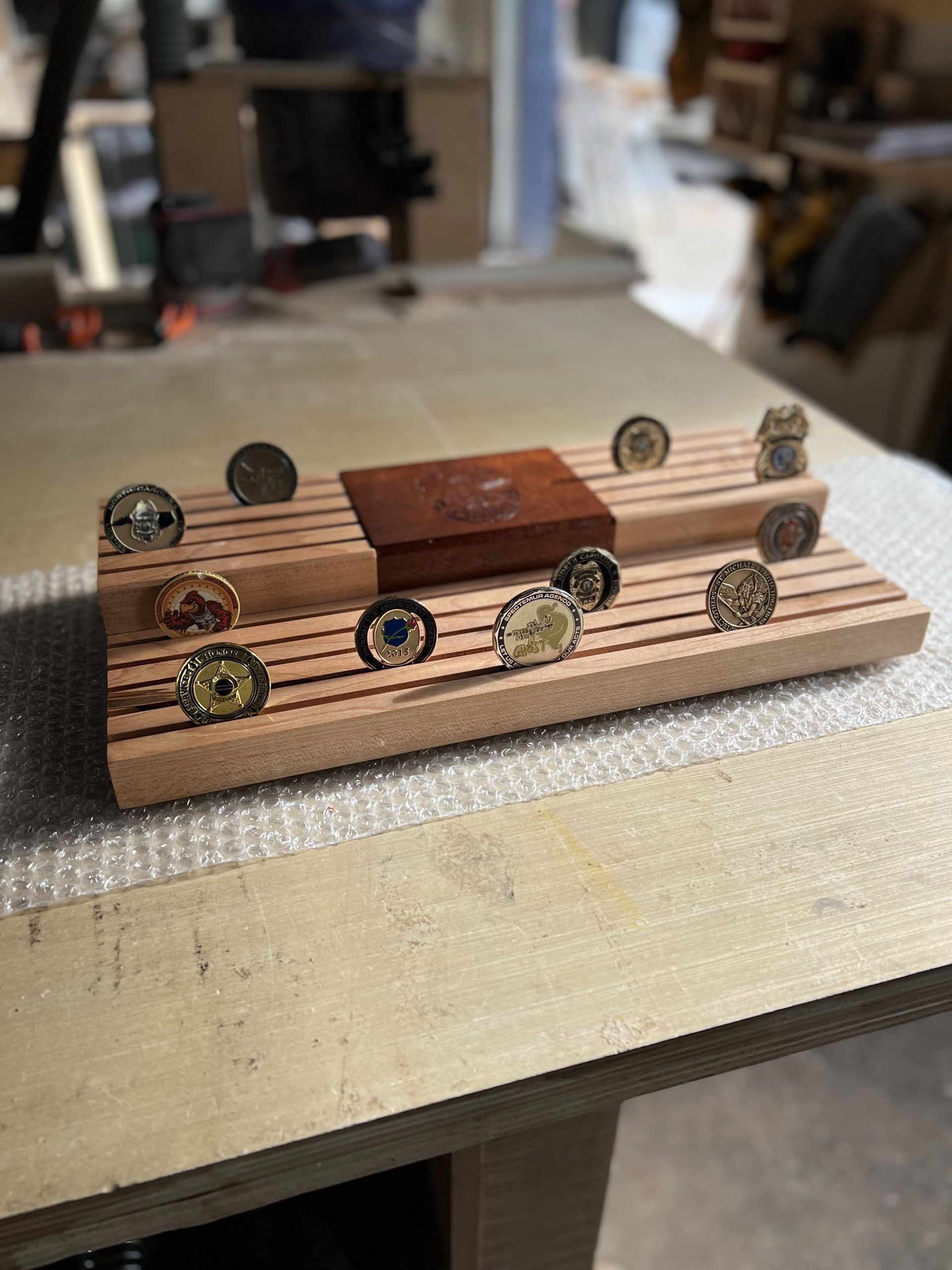 A wooden tray with coins on it is sitting on a table.