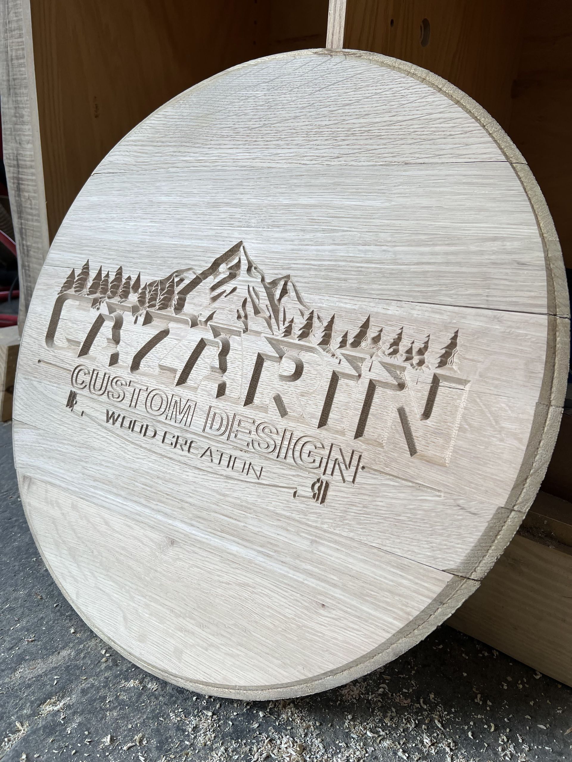 A wooden circle with a mountain carved into it is sitting on a table.