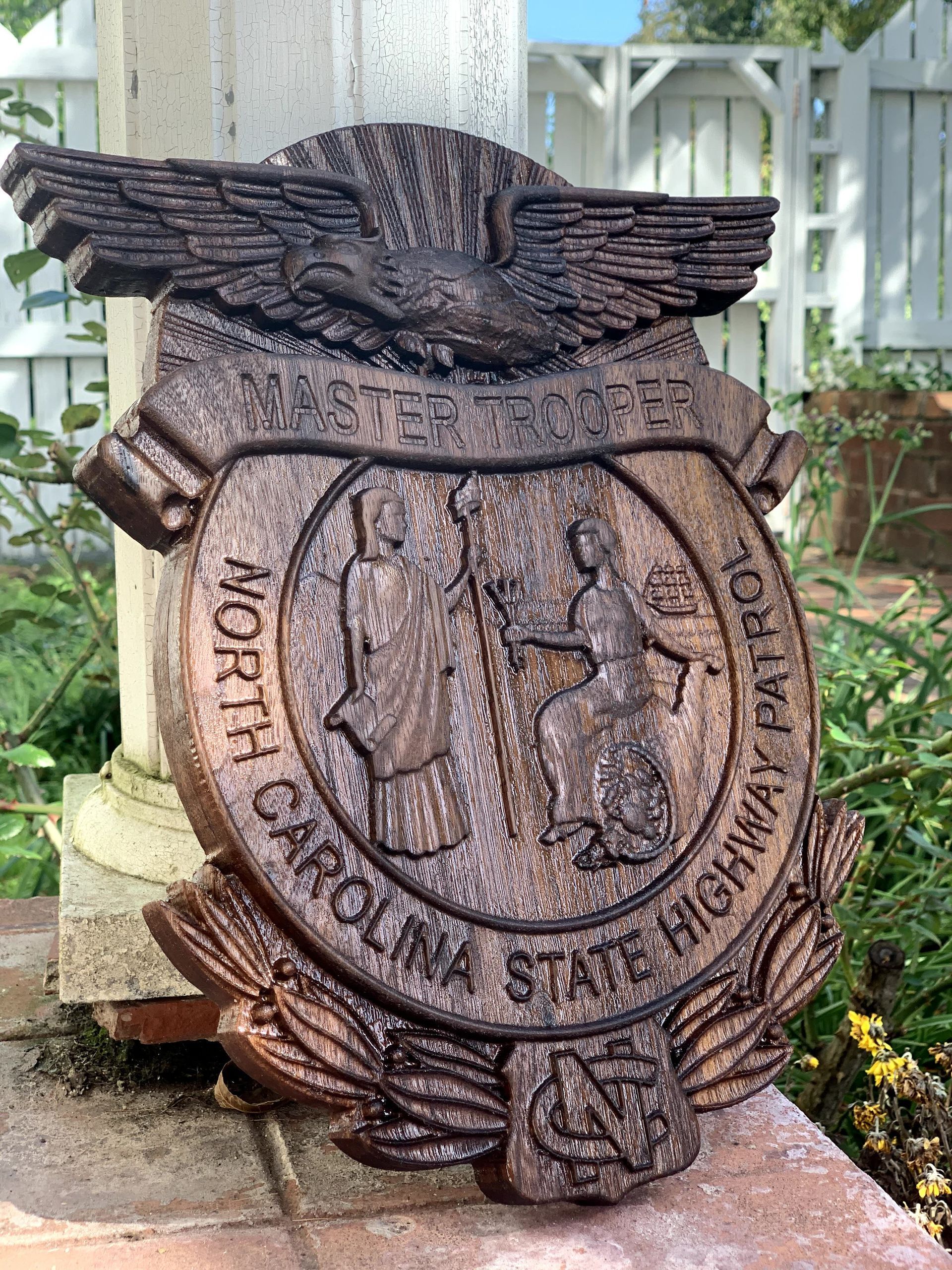 A carolina state highway sign is sitting on a brick wall.