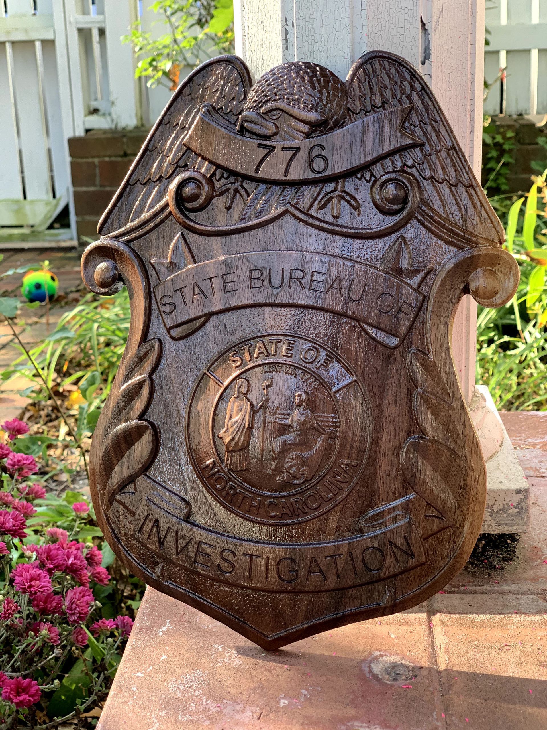 A state police badge is sitting on top of a brick wall.