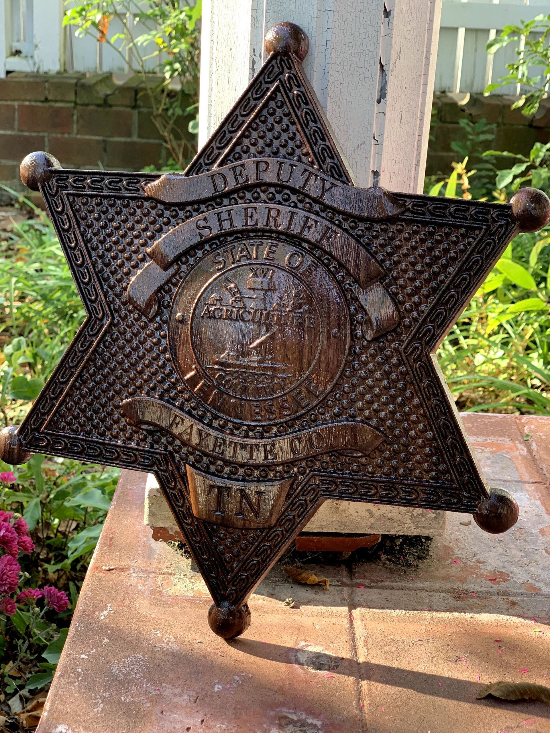A sheriff 's badge is sitting on a brick sidewalk.