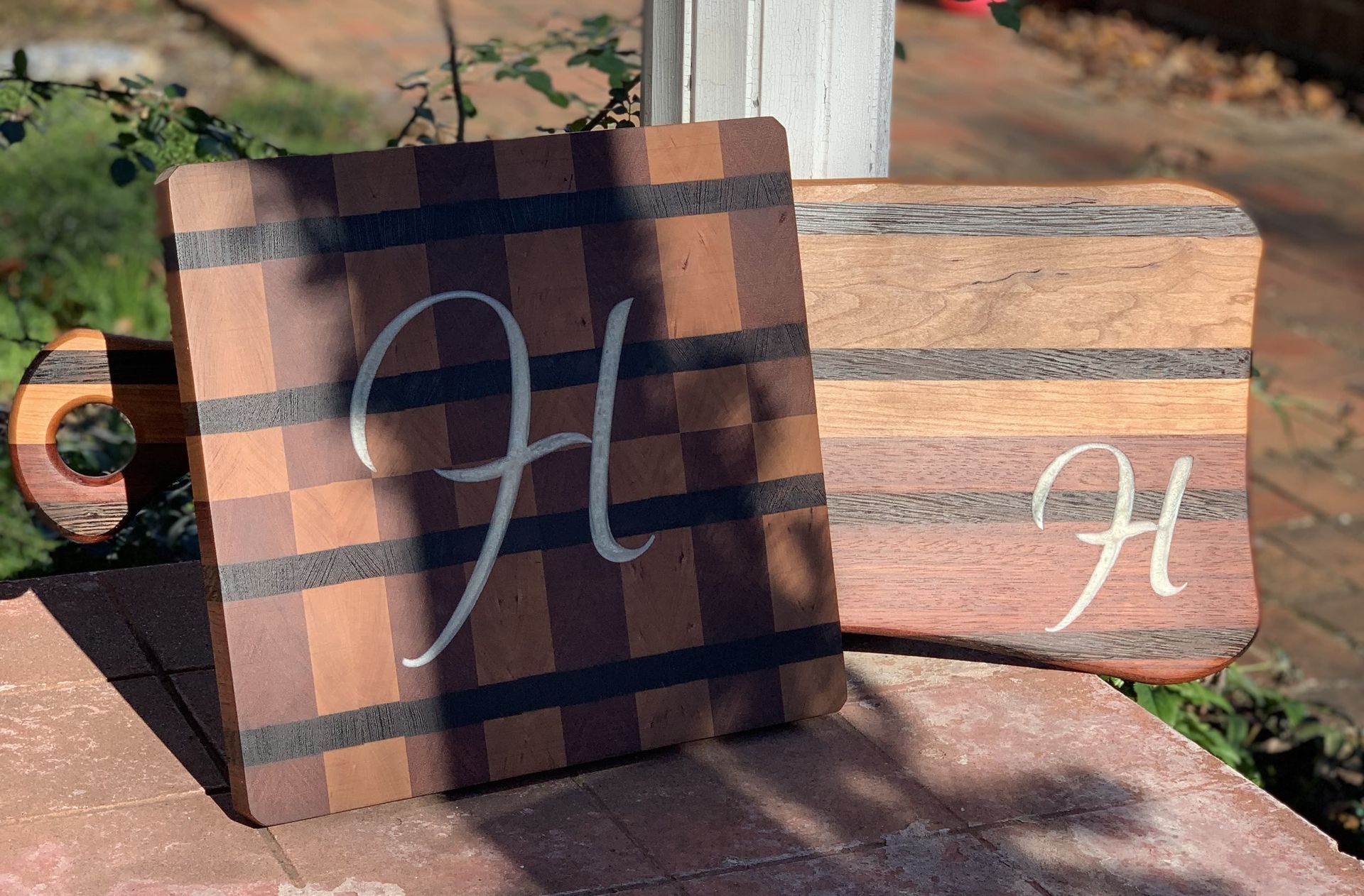A wooden cutting board with the letter h on it