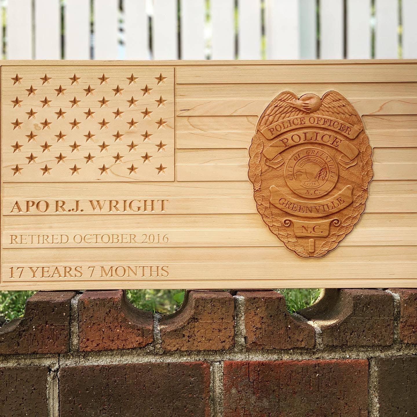 A wooden american flag with a police badge on it