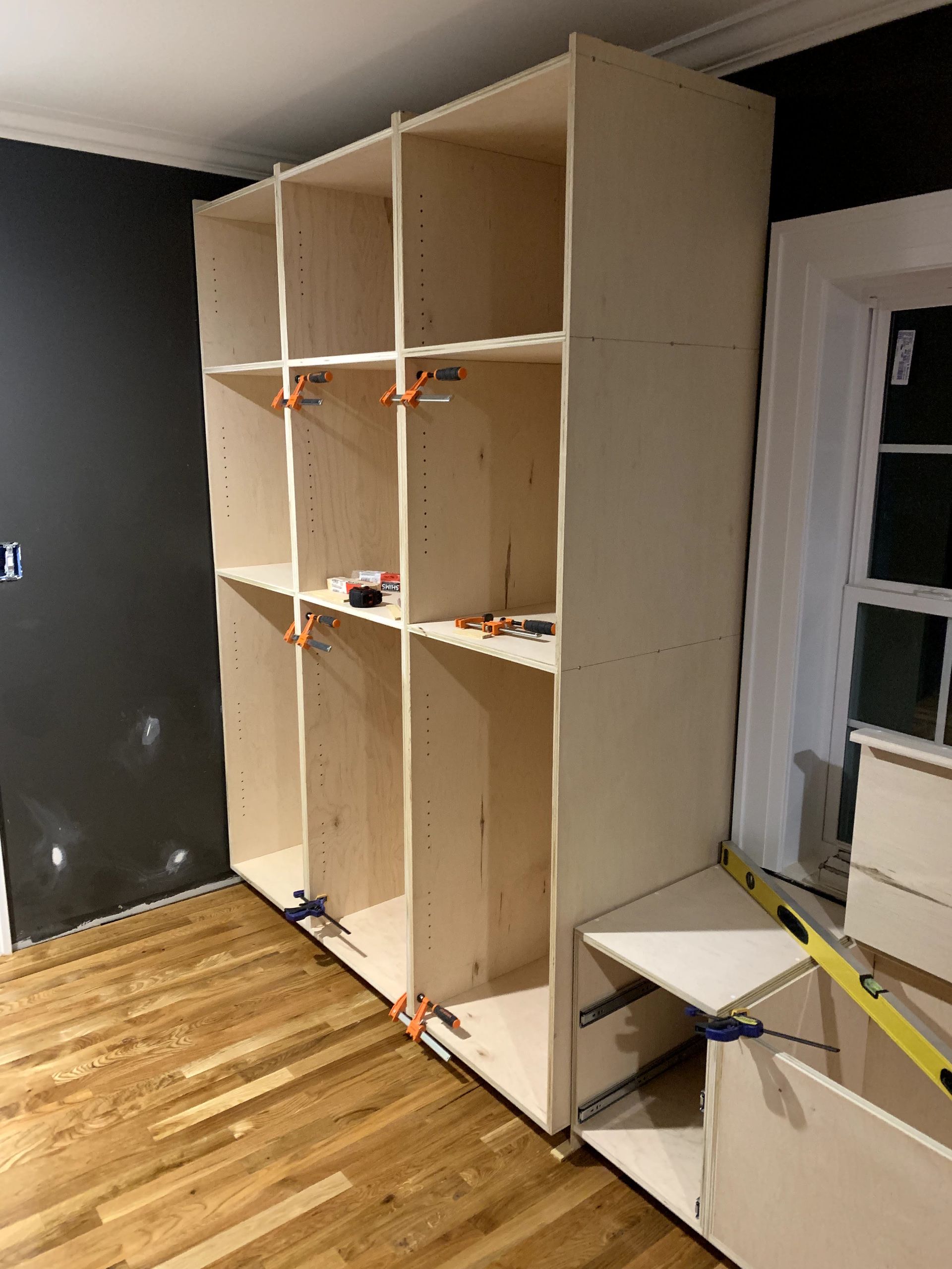 A room with a lot of shelves and a wooden floor.