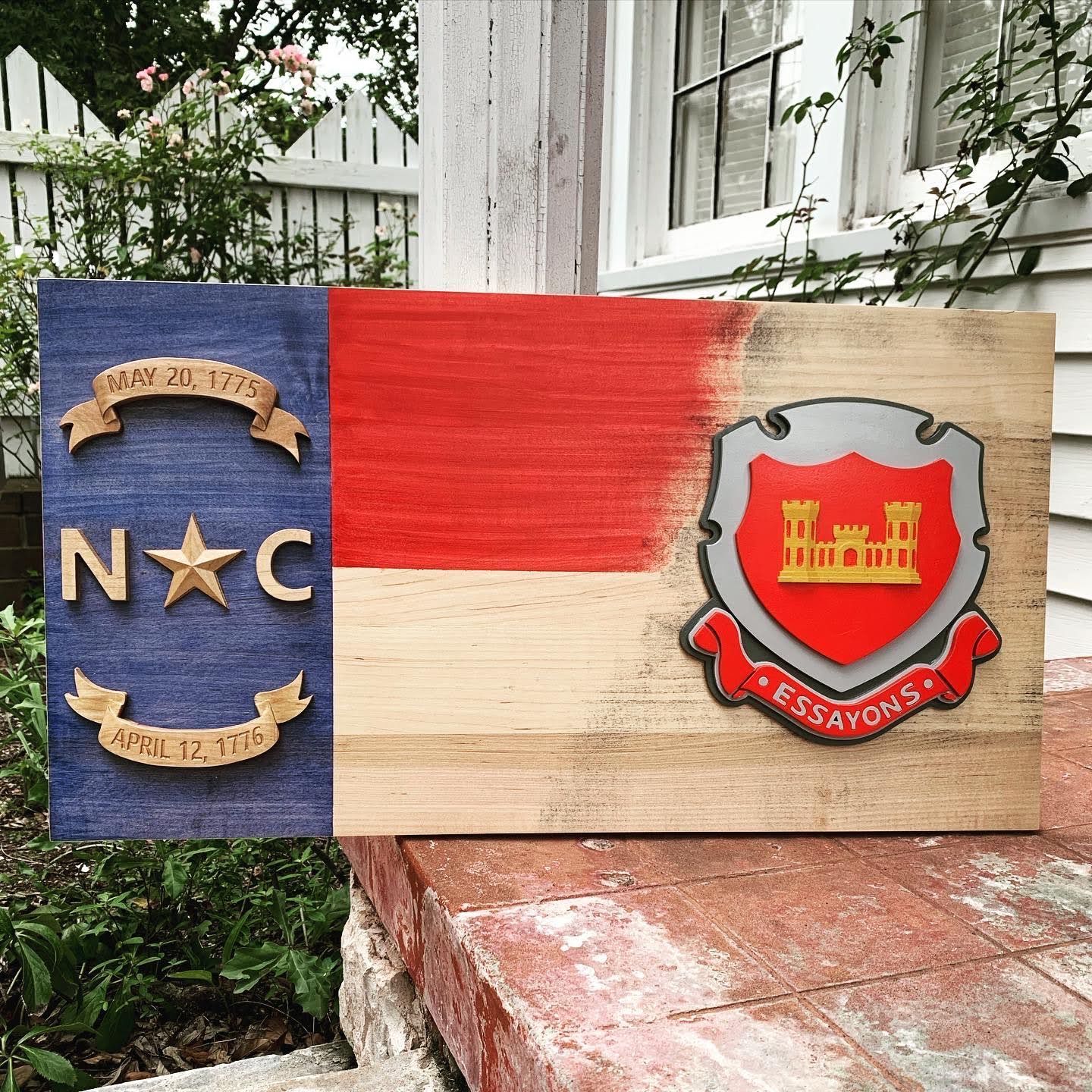 A wooden flag with a coat of arms on it is sitting on a brick wall.