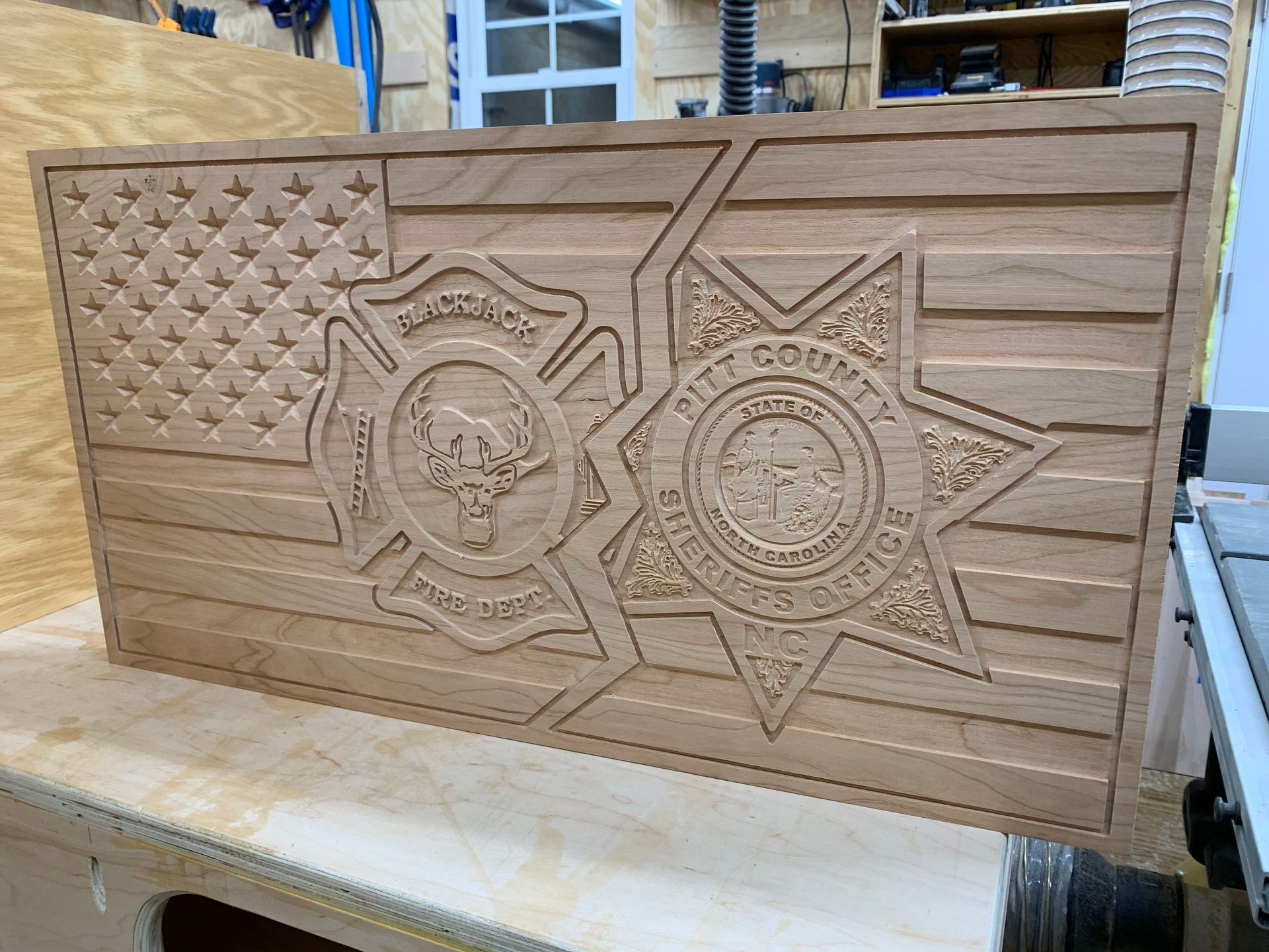 A wooden flag with a sheriff 's badge on it is on a table.