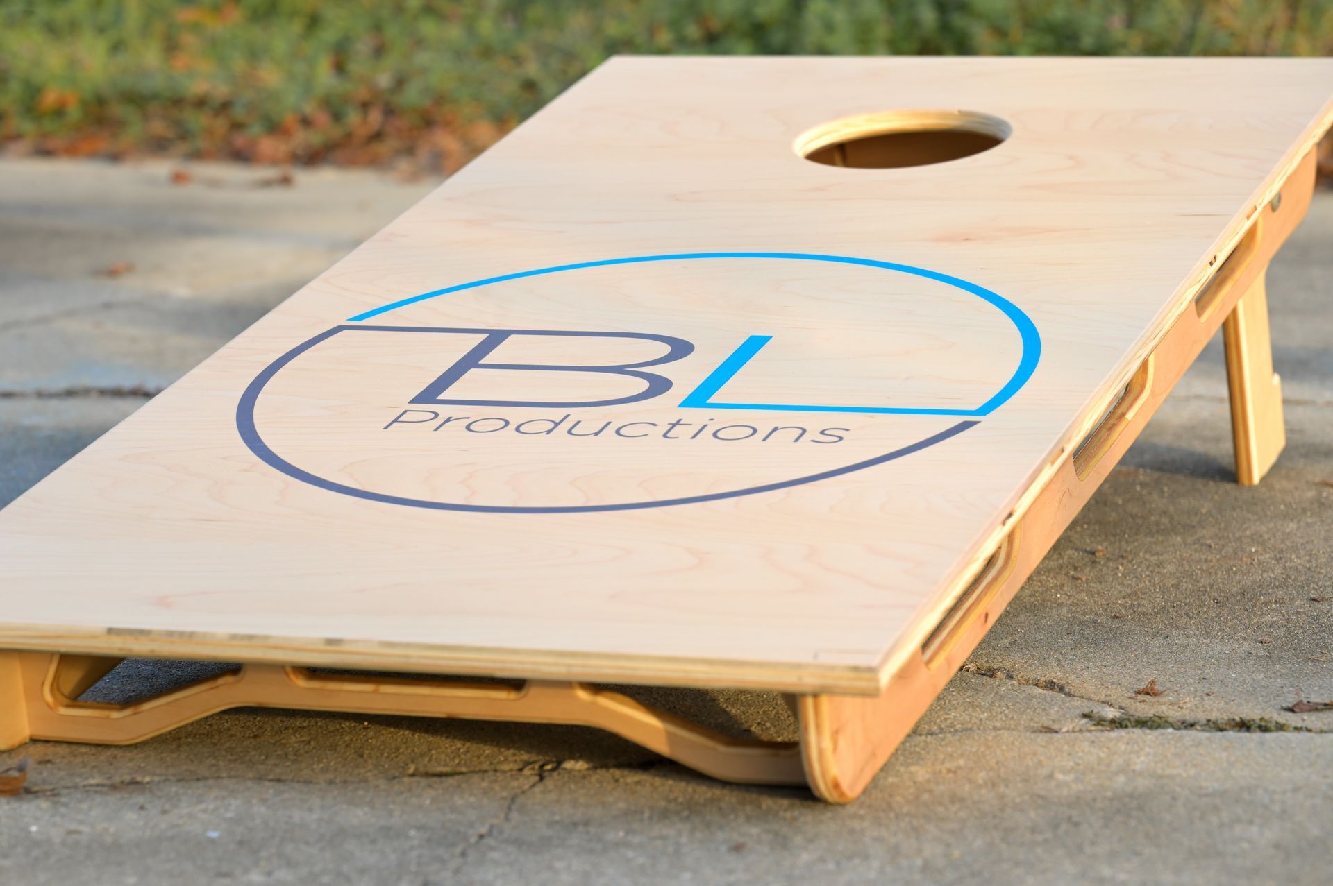 A wooden cornhole board that says bl productions on it