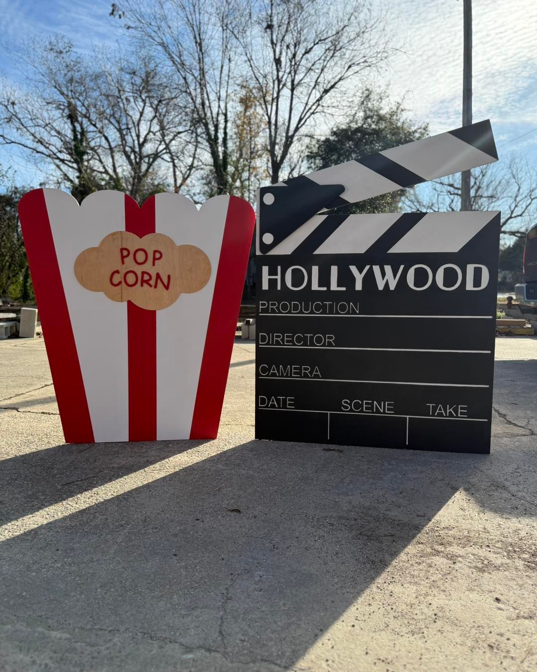 A hollywood clapper board next to a bucket of popcorn