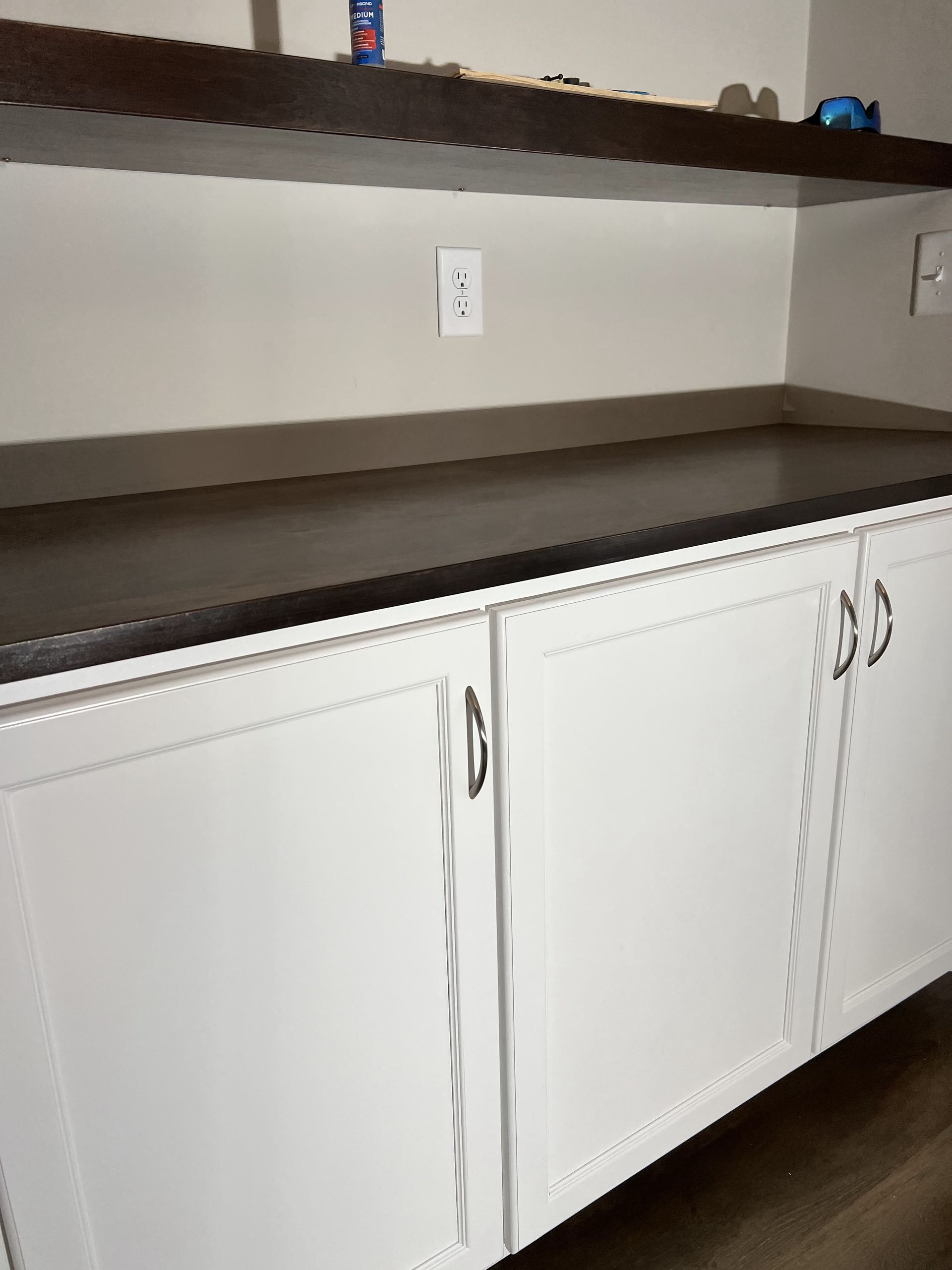 A kitchen with white cabinets and a black counter top