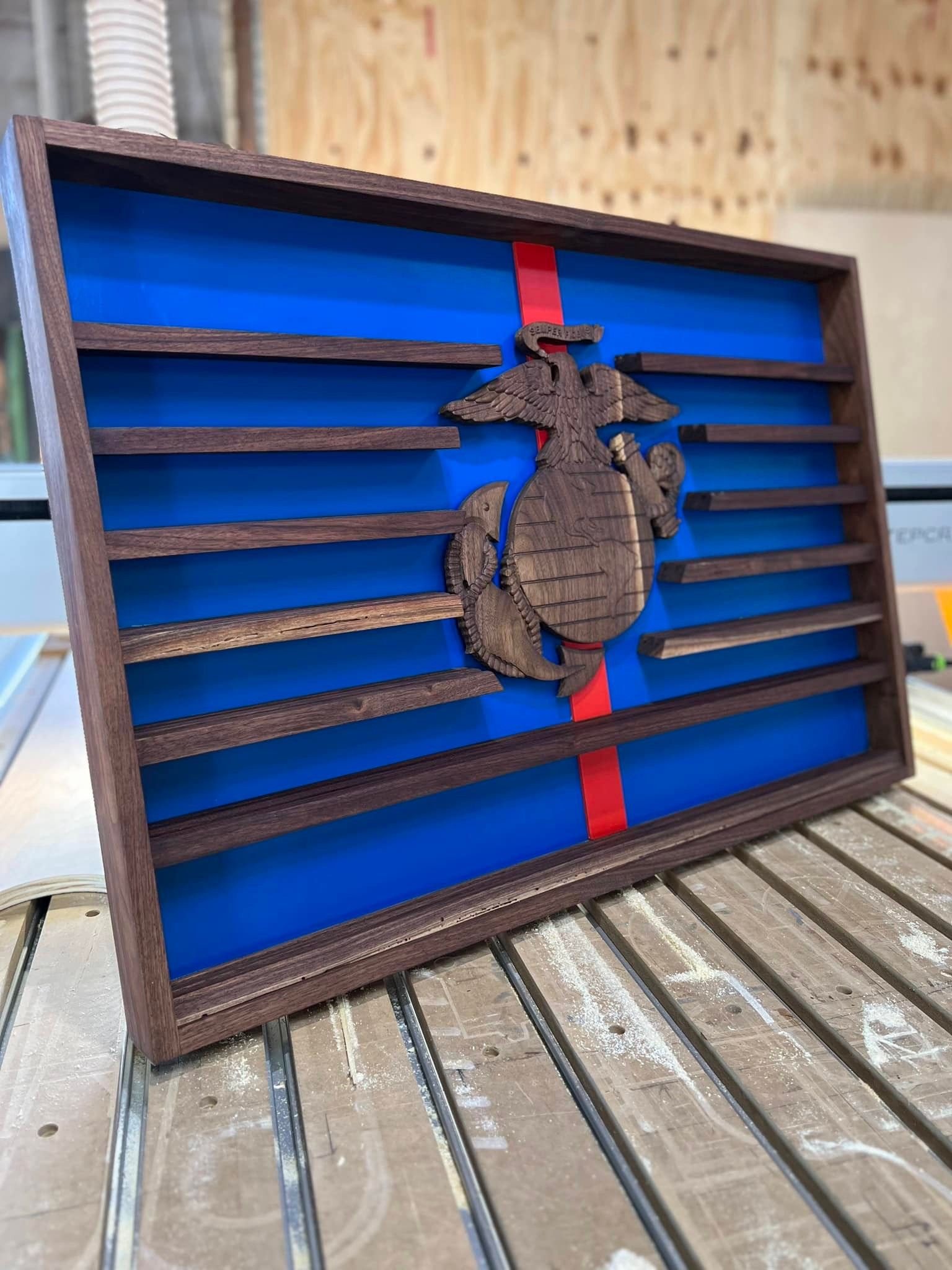 A wooden box with a marine emblem on it is sitting on a wooden table.