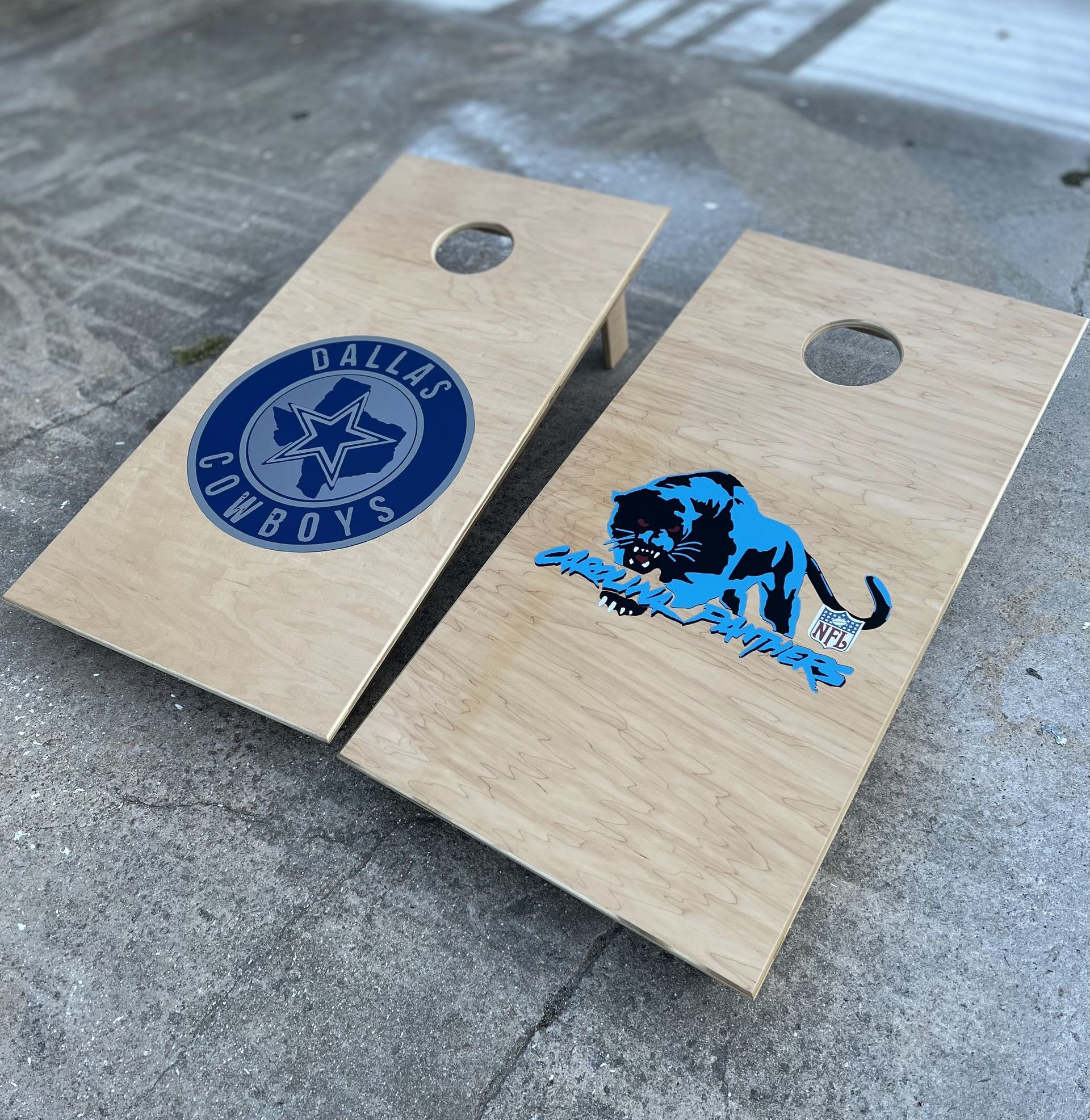 Two wooden bags with dallas cowboys and panthers logos on them