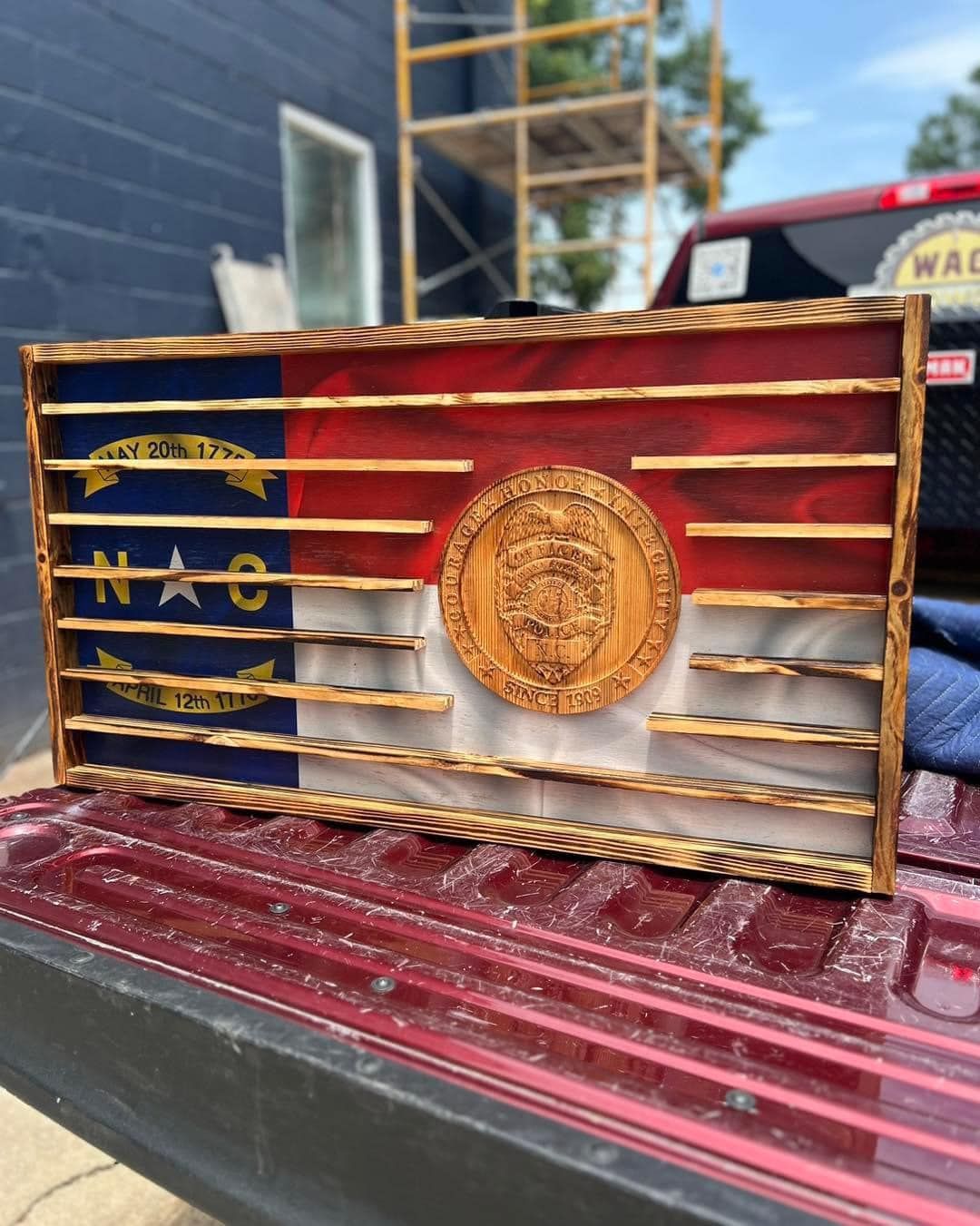 A wooden flag is sitting on the back of a truck.