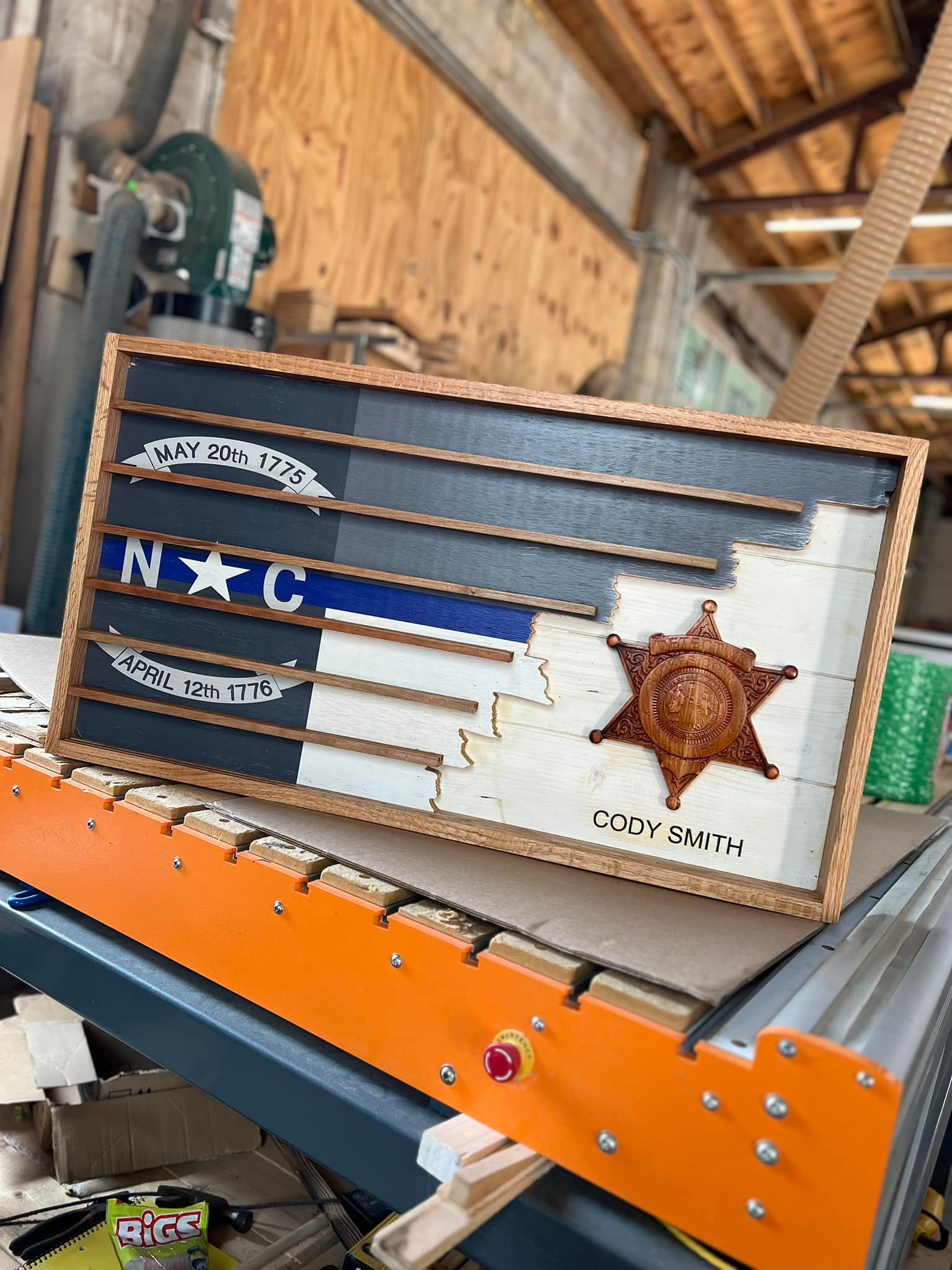 A wooden flag with a sheriff 's badge on it is sitting on top of a wooden table.