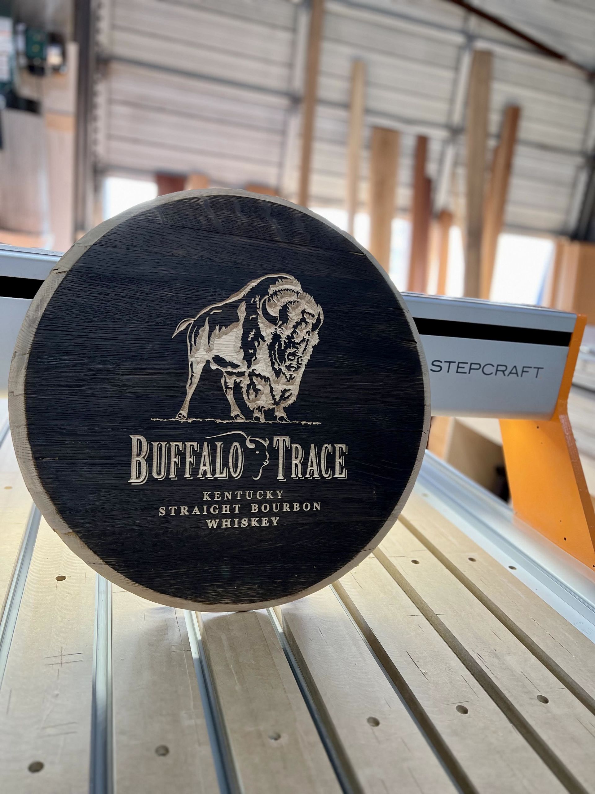 A wooden circle with a buffalo on it is sitting on a wooden table.