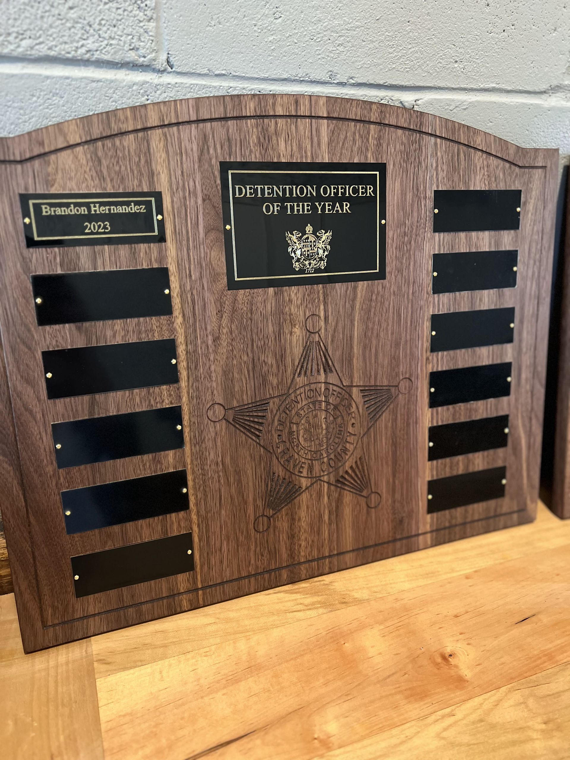 A wooden plaque with a star on it is sitting on a wooden table.