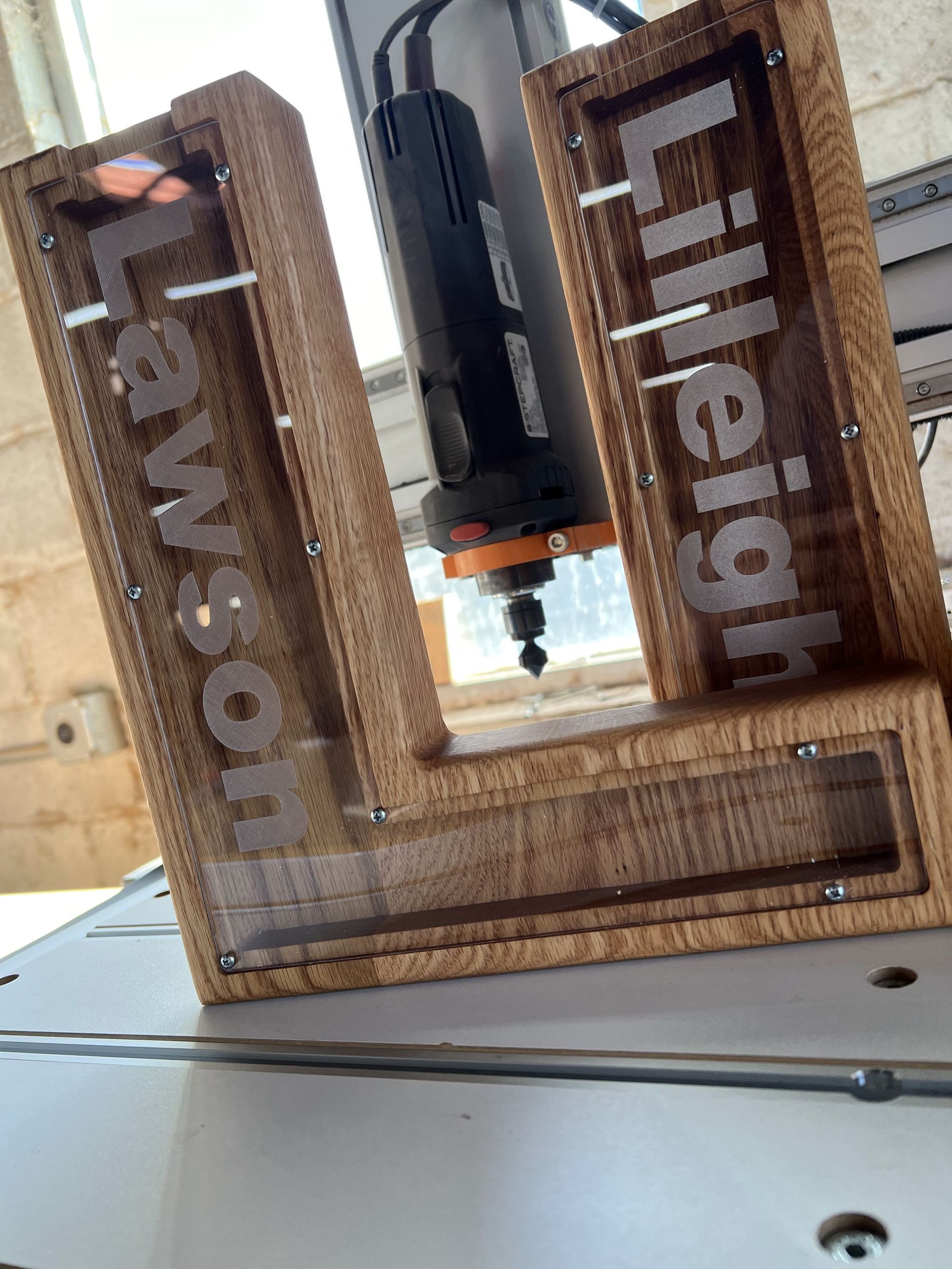 A wooden letter u is sitting on top of a table next to a machine.