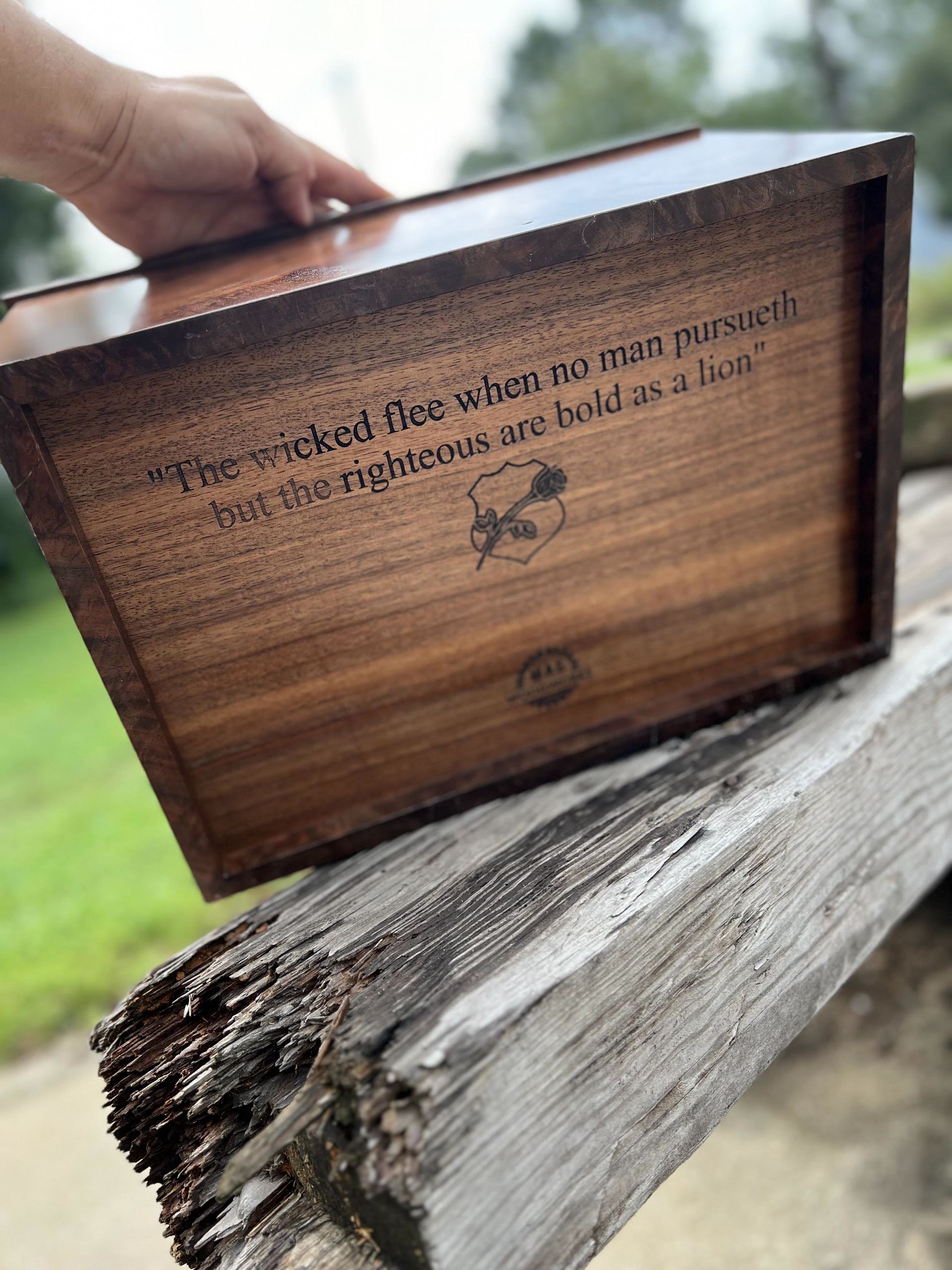 A person is holding a wooden box with a quote on it.