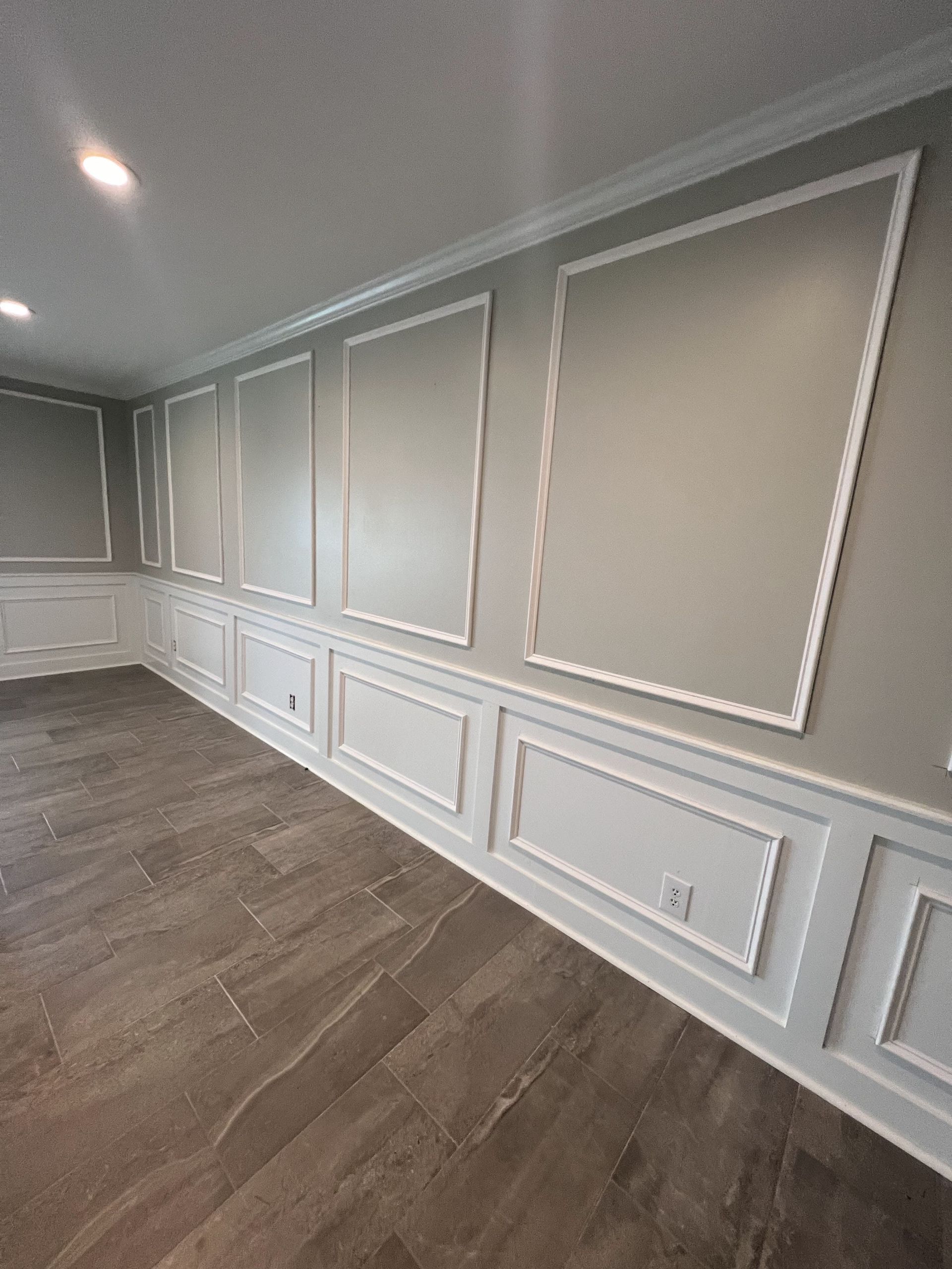 A room with a lot of white trim on the walls and a wooden floor.