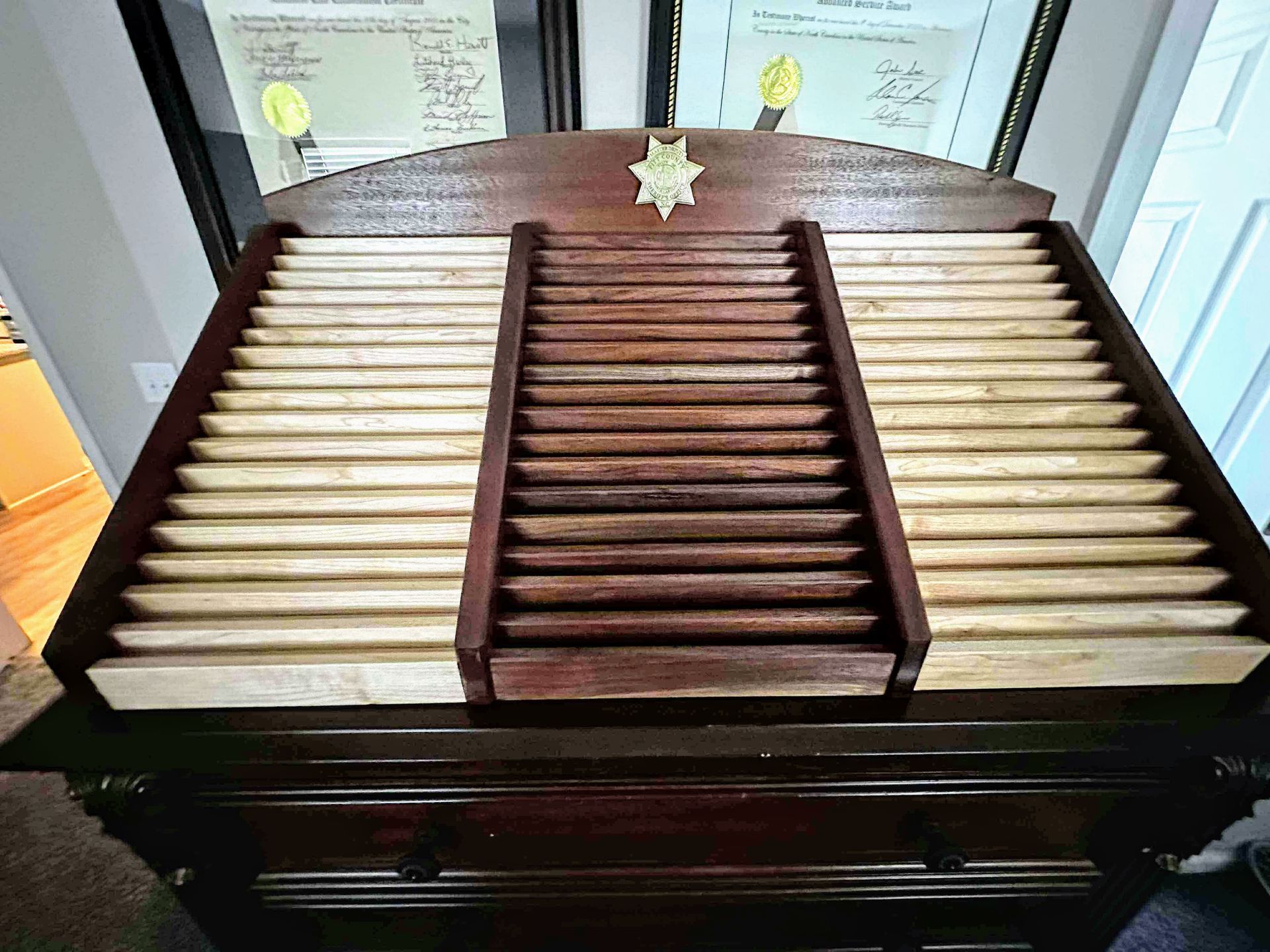 A wooden table with a sheriff 's badge on top of it.