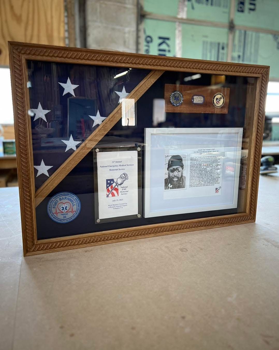 A framed american flag is sitting on top of a wooden table.