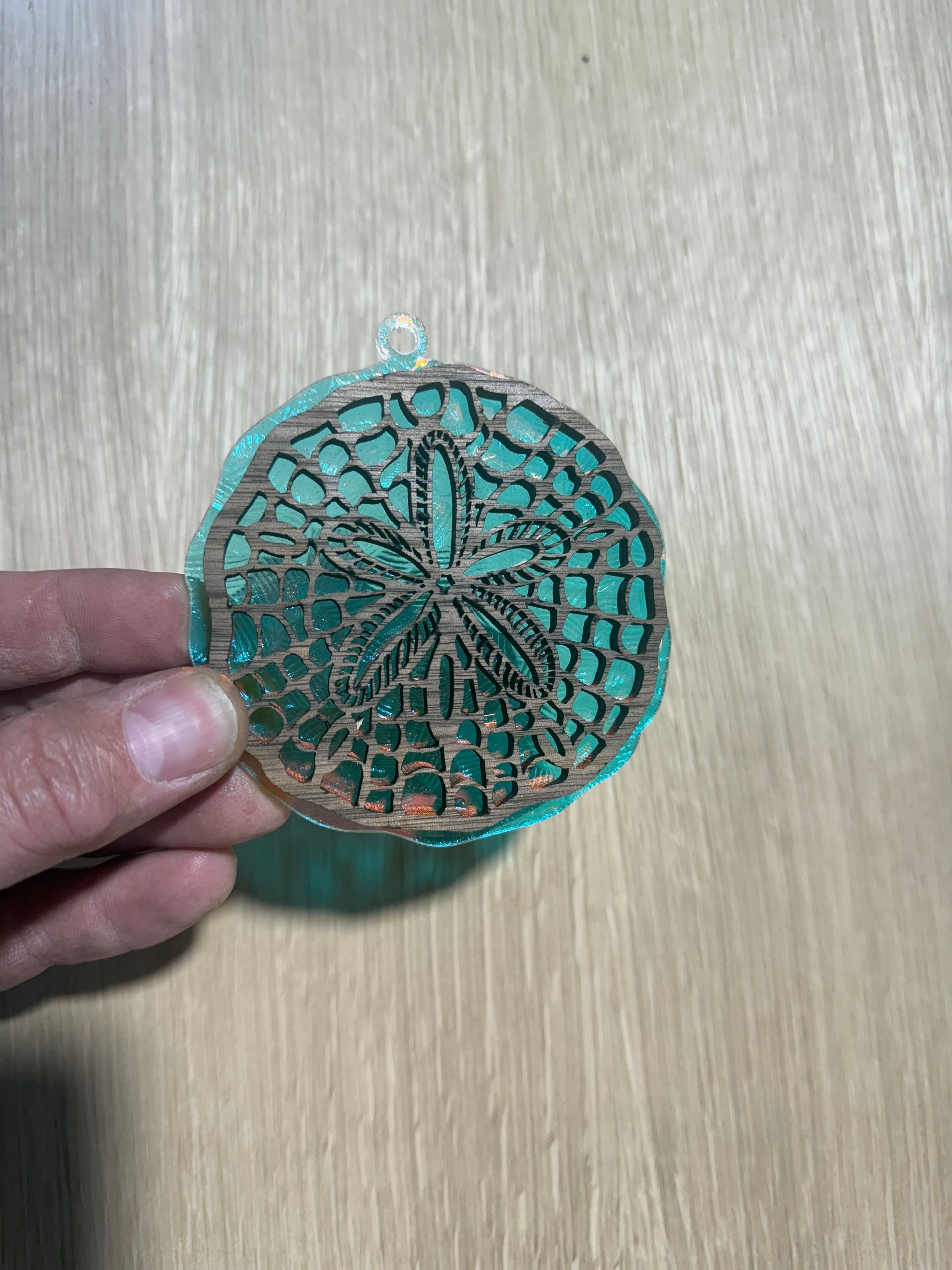 A person is holding a piece of wood in their hand on a wooden table.