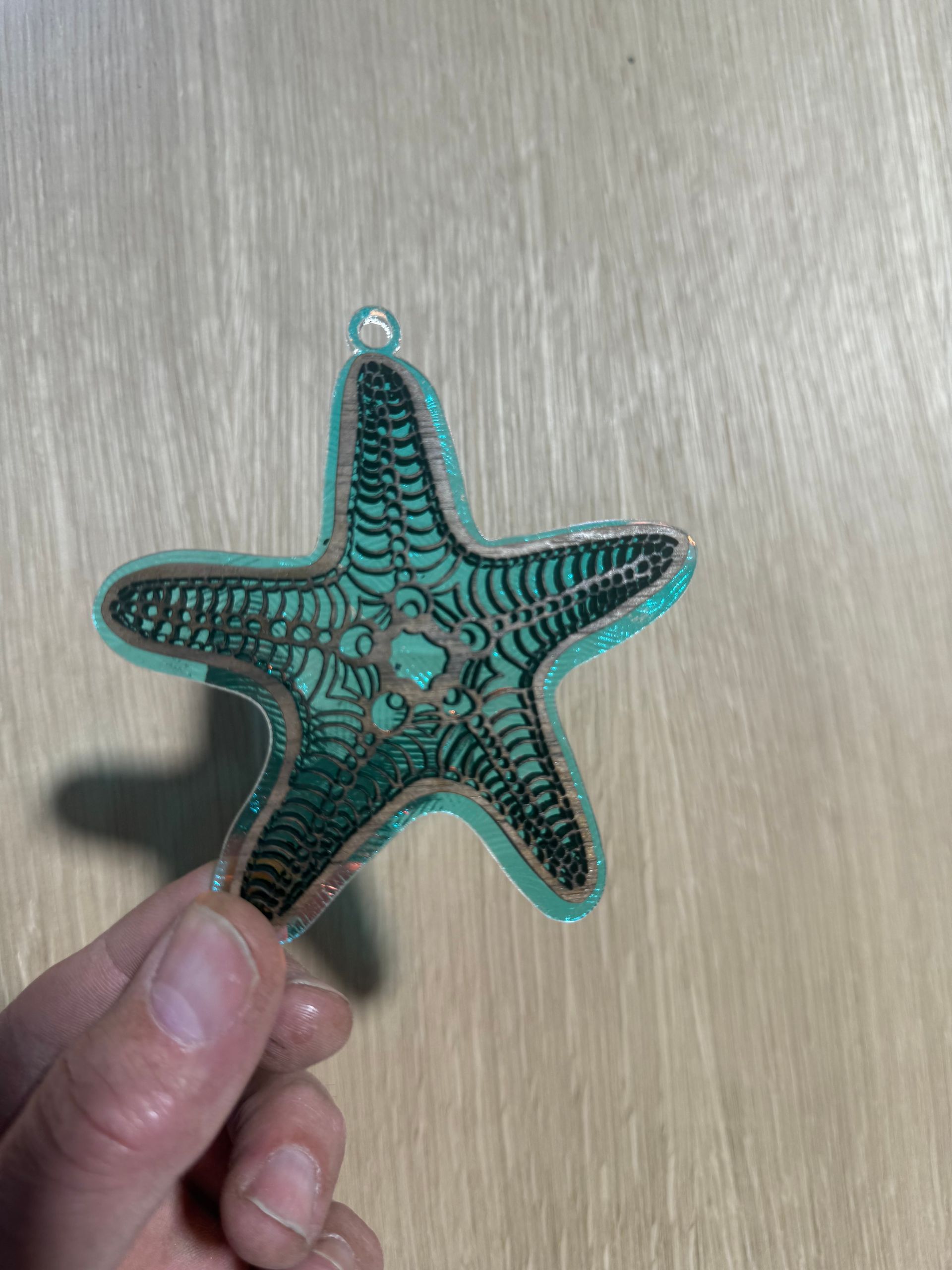 A person is holding a starfish ornament in their hand.