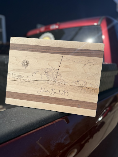 A wooden cutting board is sitting on the back of a truck.