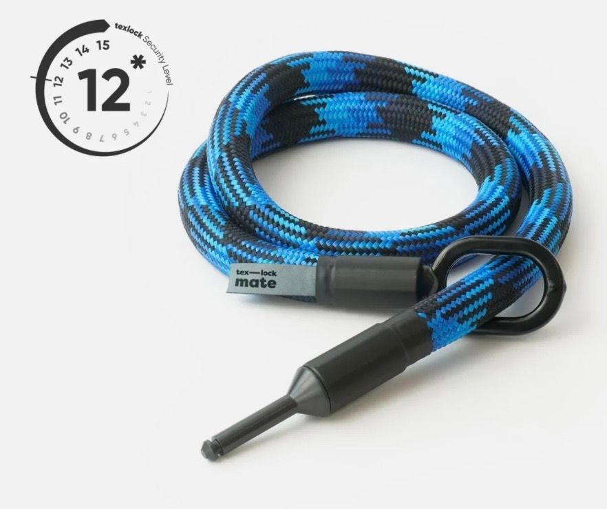 Blue and black patterned rope with a black connector and a tool, coiled on a white surface.