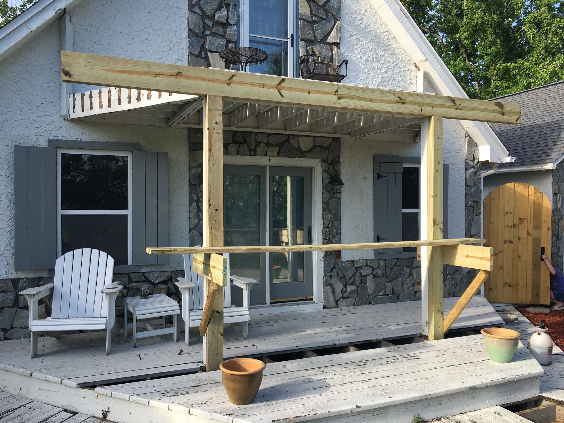 A white house with a wooden deck in front of it