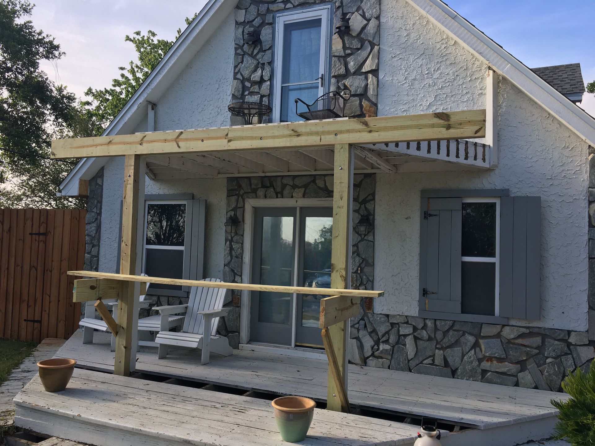 A white house with a wooden porch and chairs