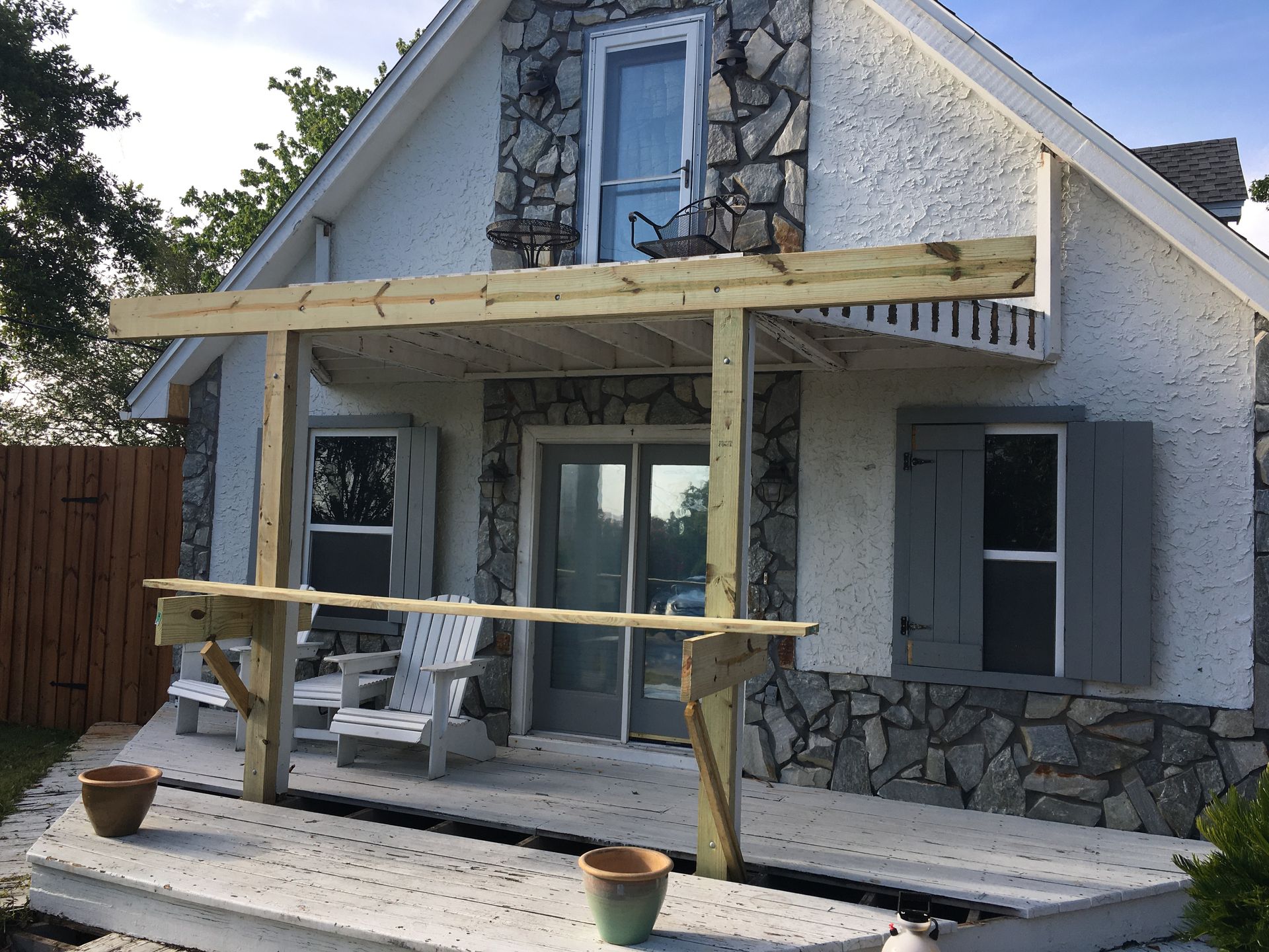 A house with a wooden porch and chairs on it