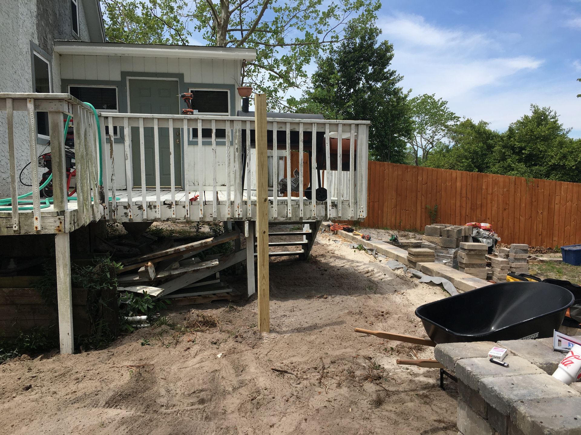 A house with a deck and a wheelbarrow in front of it
