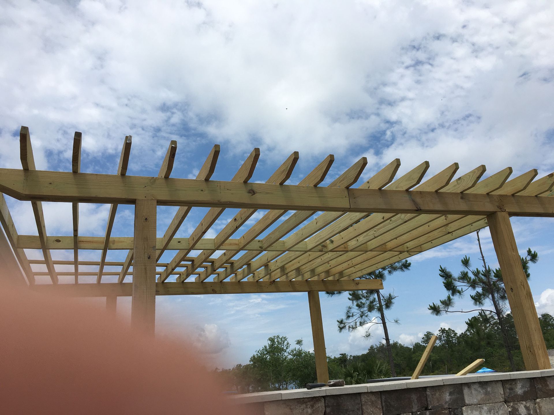 A wooden pergola with a blue sky in the background