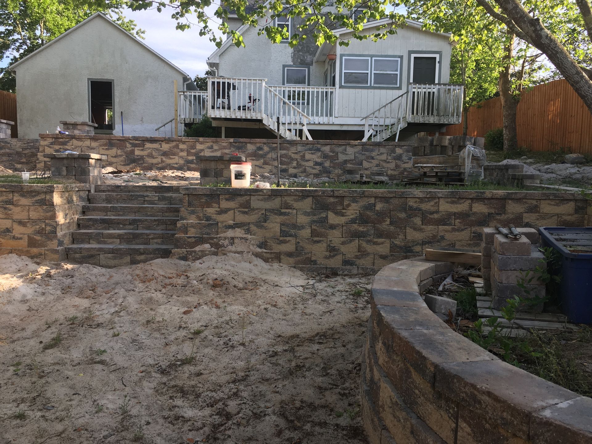 A house with a deck and stairs is being built on a hill.