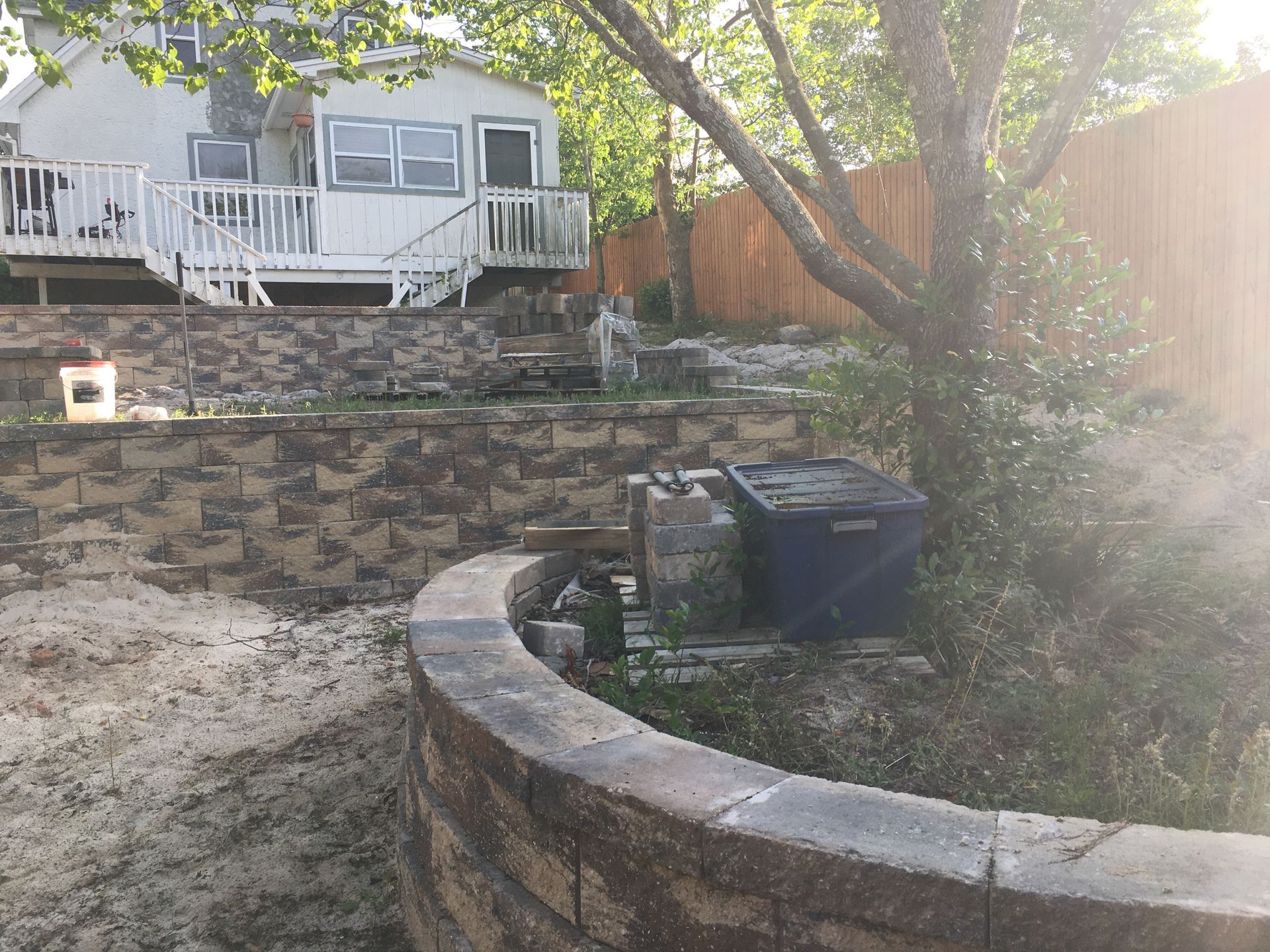 A backyard with a brick wall and a house in the background