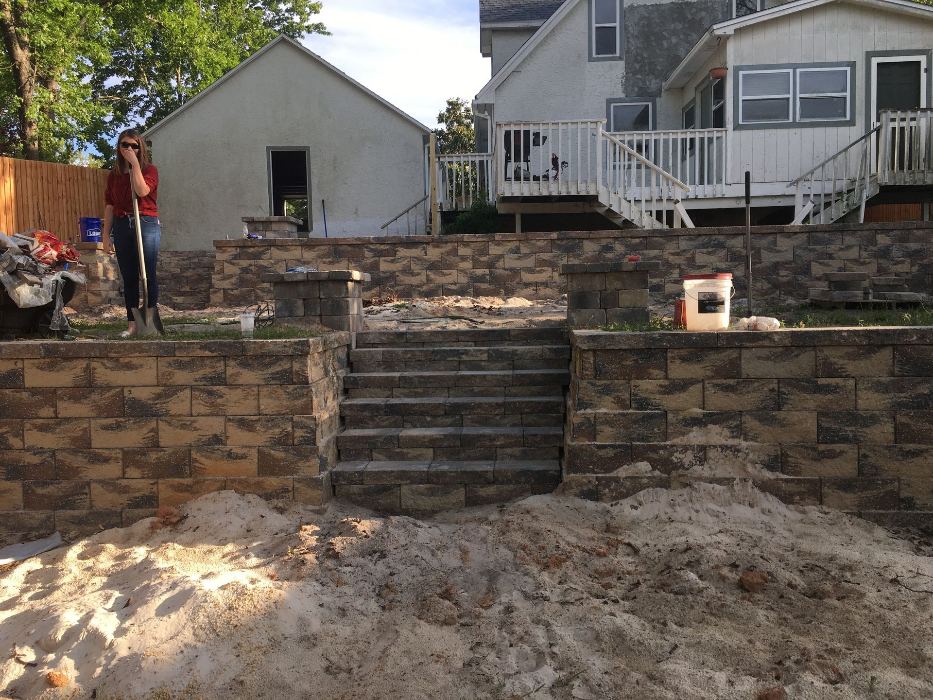 A brick wall is being built in front of a house