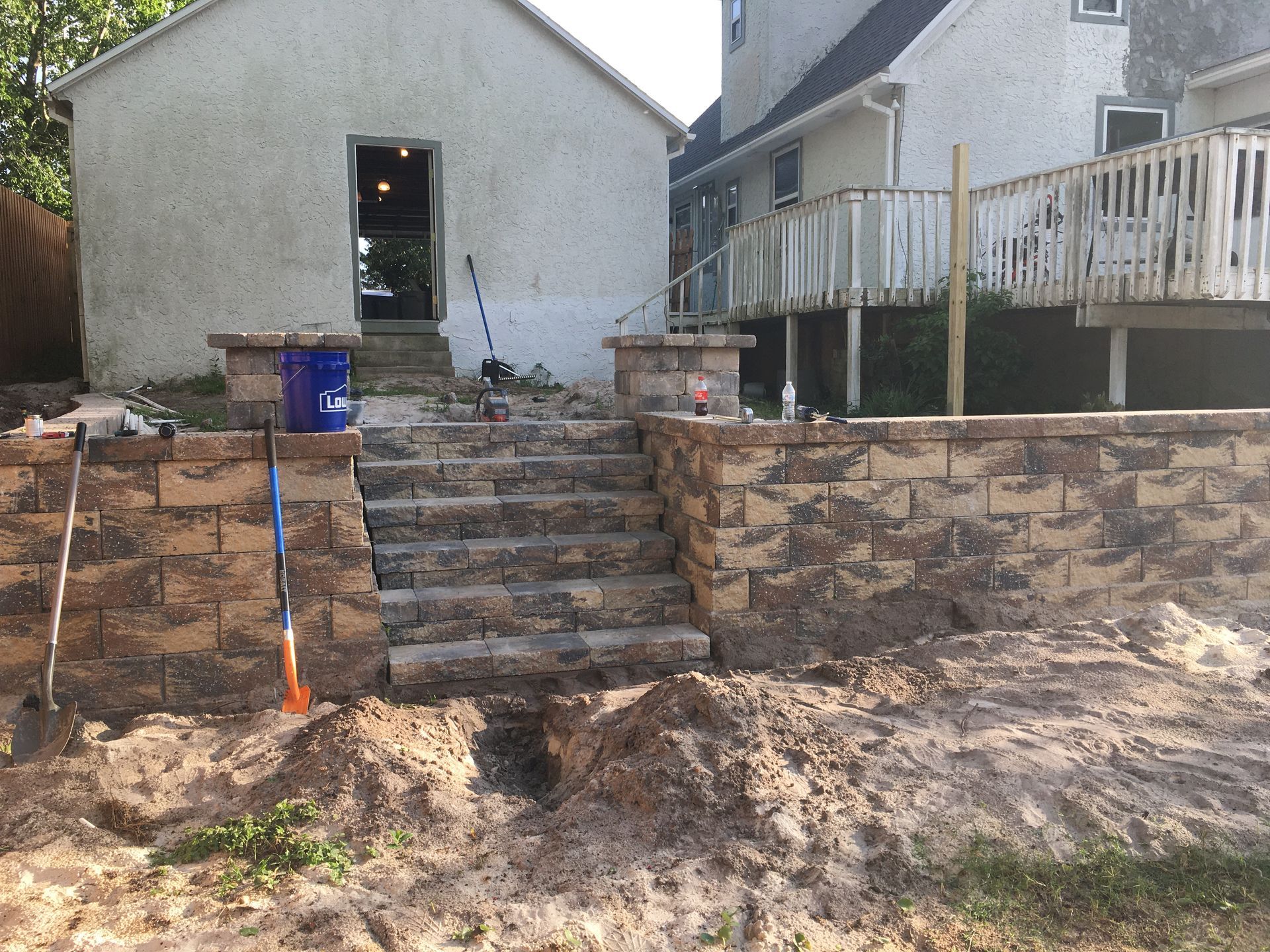 A brick wall is being built in front of a house