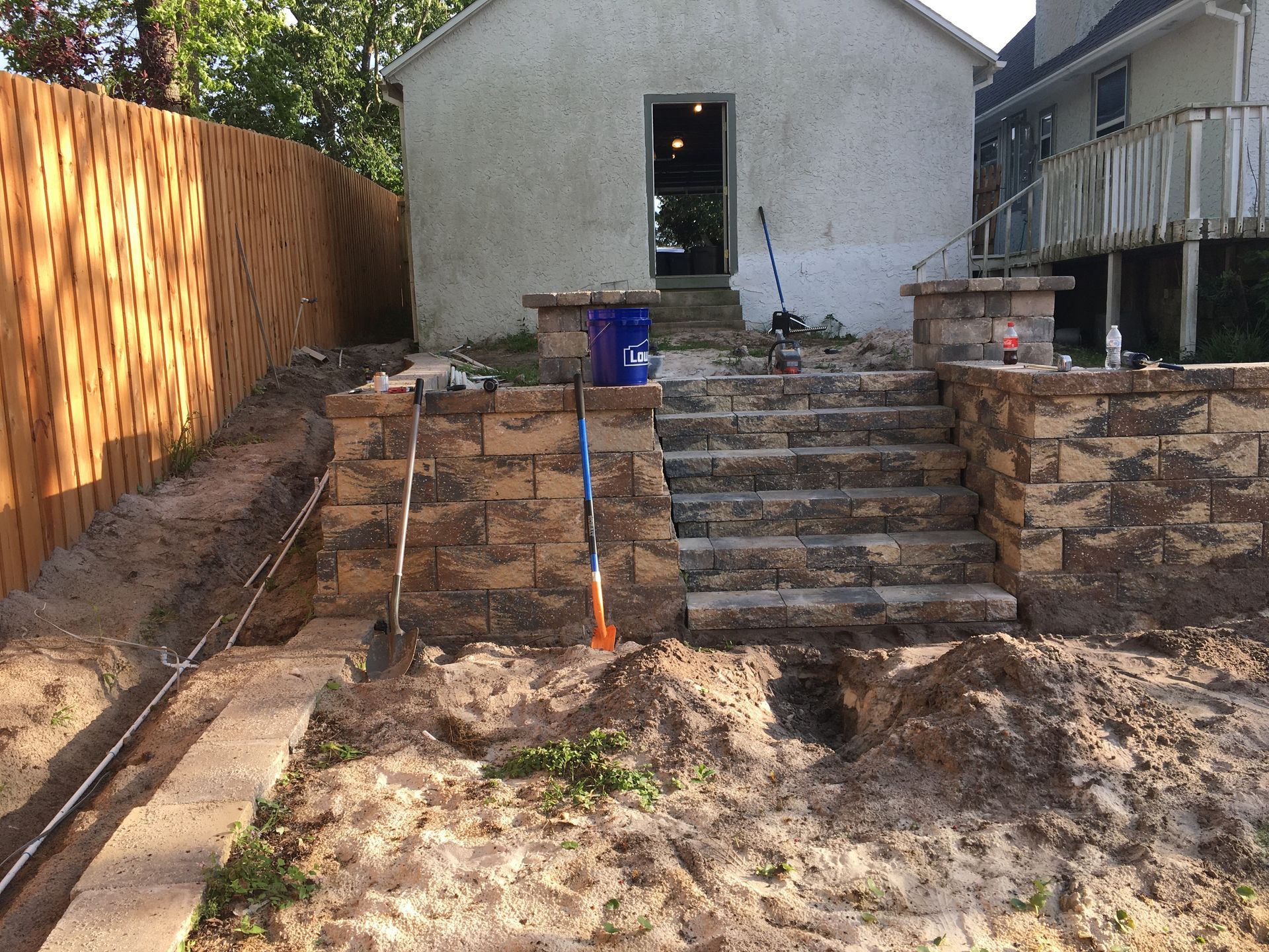 A brick wall is being built in front of a house