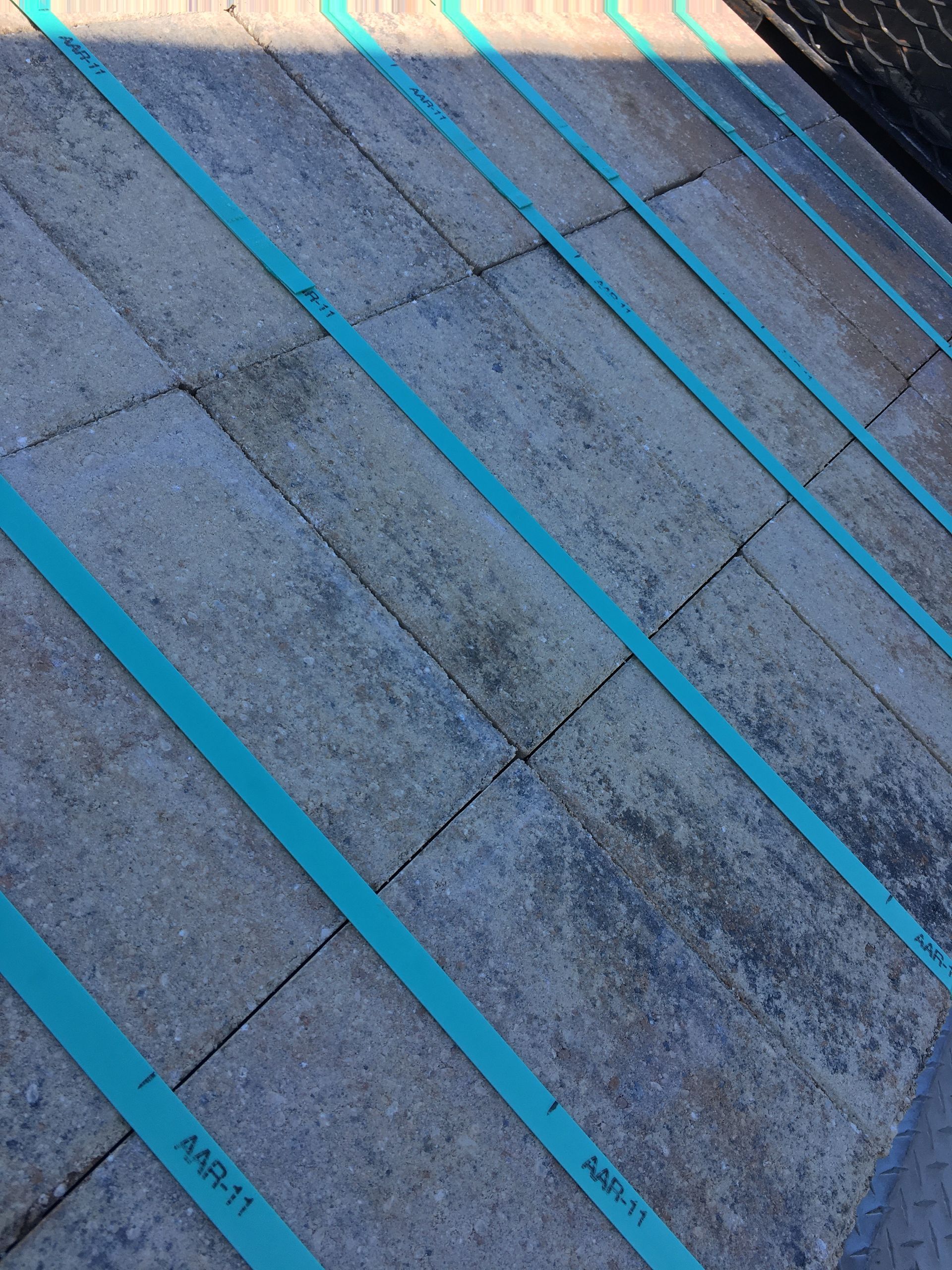 A close up of a brick floor with blue tape on it